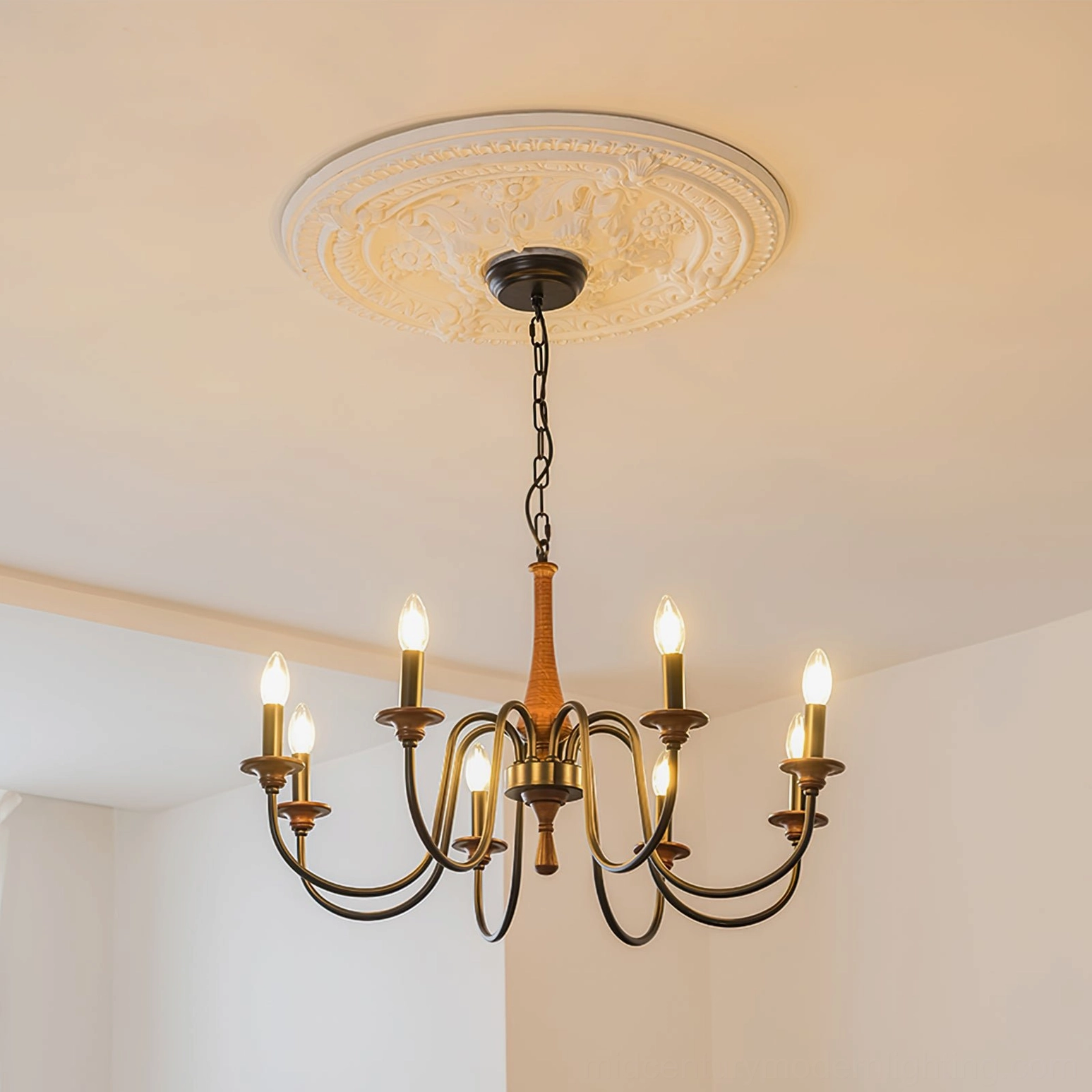 Aubrey chandelier installed in elegant living room with decorative ceiling medallion and warm candle-style bulb lighting