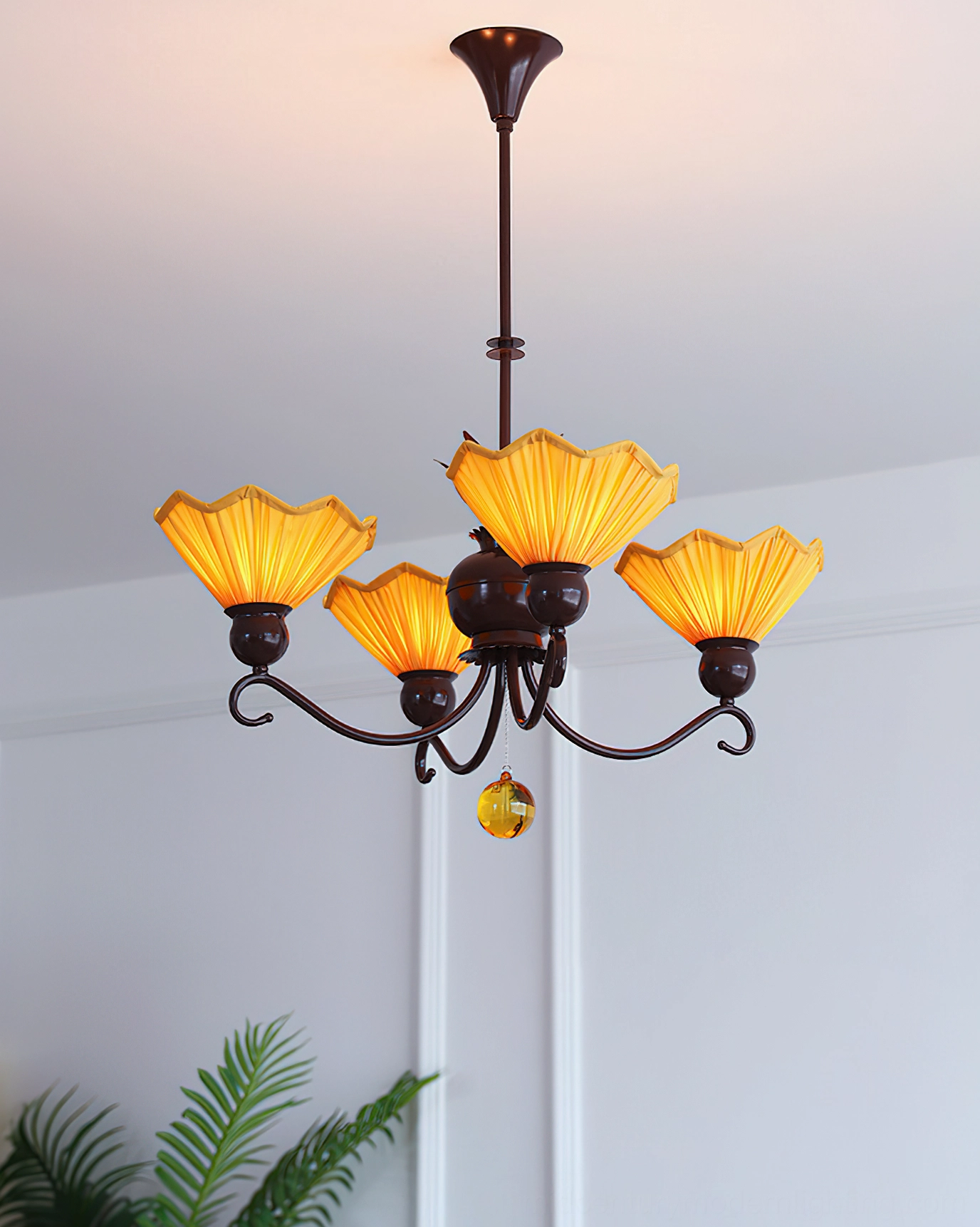 Aurelia 5-light pleated chandelier with brown scroll arms and amber fabric shades against white wall interior