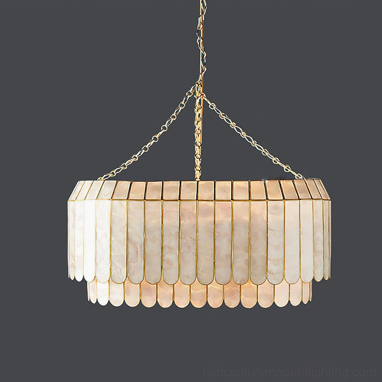 Two-tier capiz pendant lamp hanging view on dark gray background, showing gold metal frame edging and shell layer construction, boho luxury aesthetic