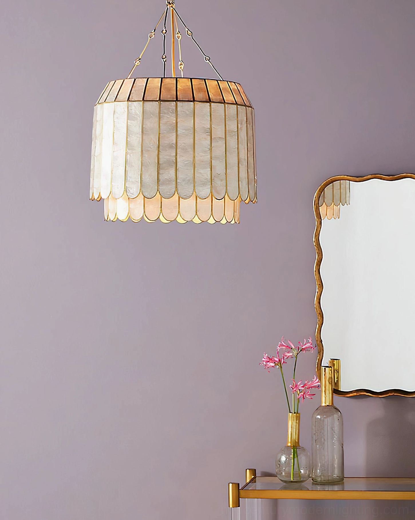 Single-tier capiz shell pendant in soft vanity space with purple walls and scalloped mirror frame, compact drum design, warm glowing light