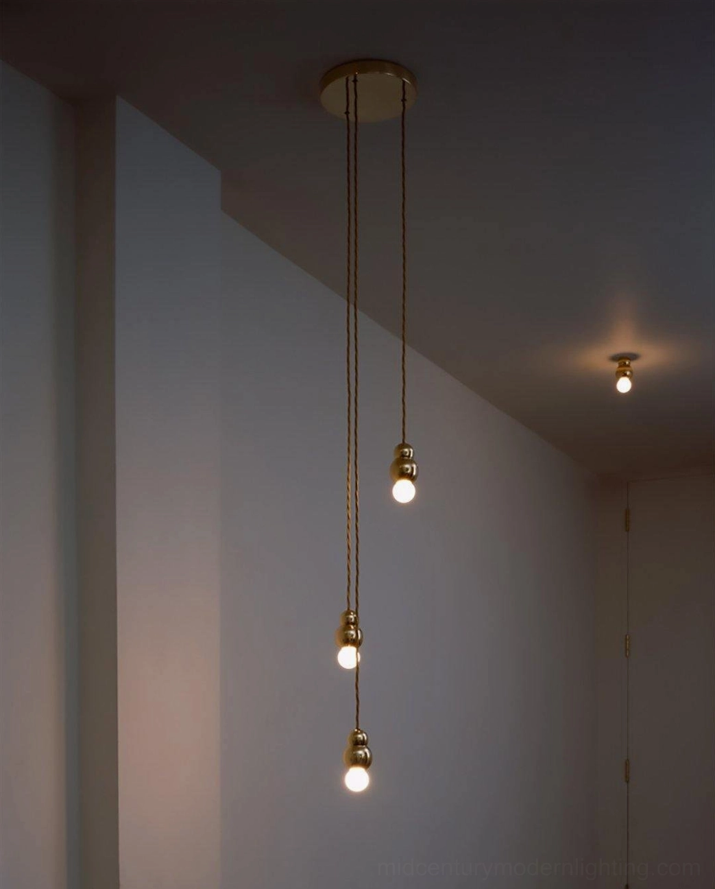 Ball pendant light installation view, suspended from ceiling with visible cord and modern bulb glow