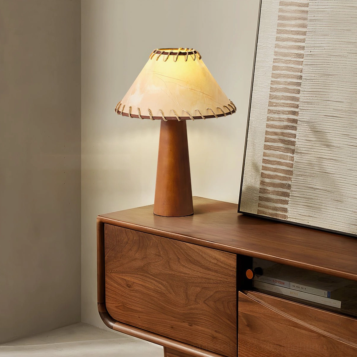 Basica table lamp positioned on walnut wood dresser cabinet with modern bedroom decor