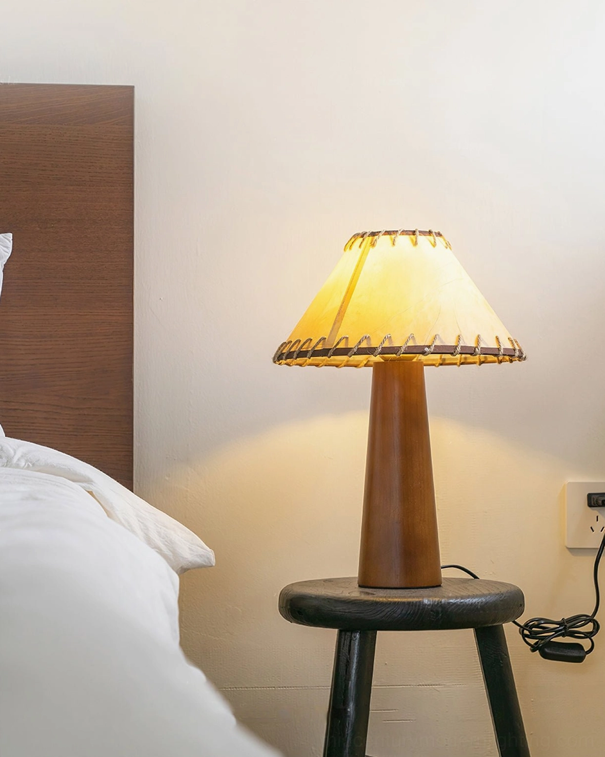 Basica modern wood table lamp positioned on bedroom nightstand, ambient bedroom lighting scenario