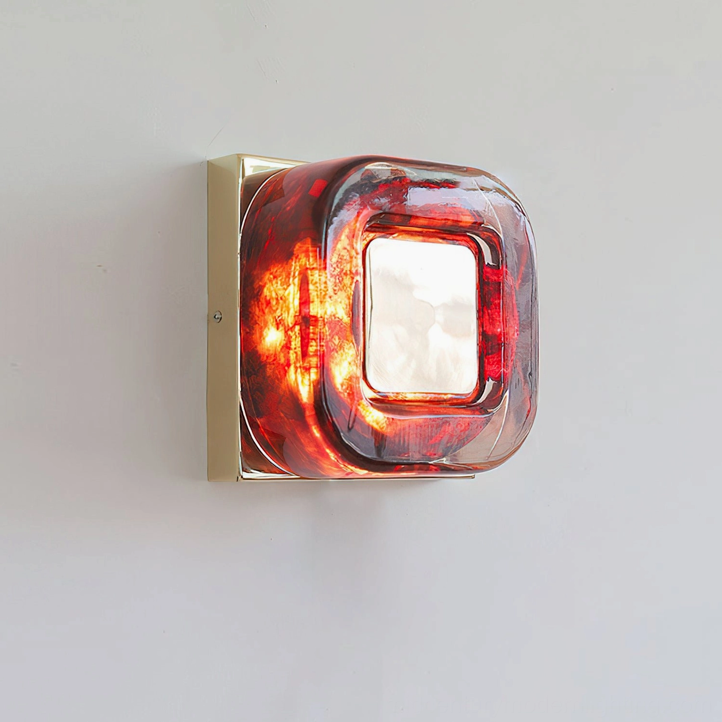 Paired red wall sconces above tufted headboard in bedroom with carved wall paneling and neutral tones
