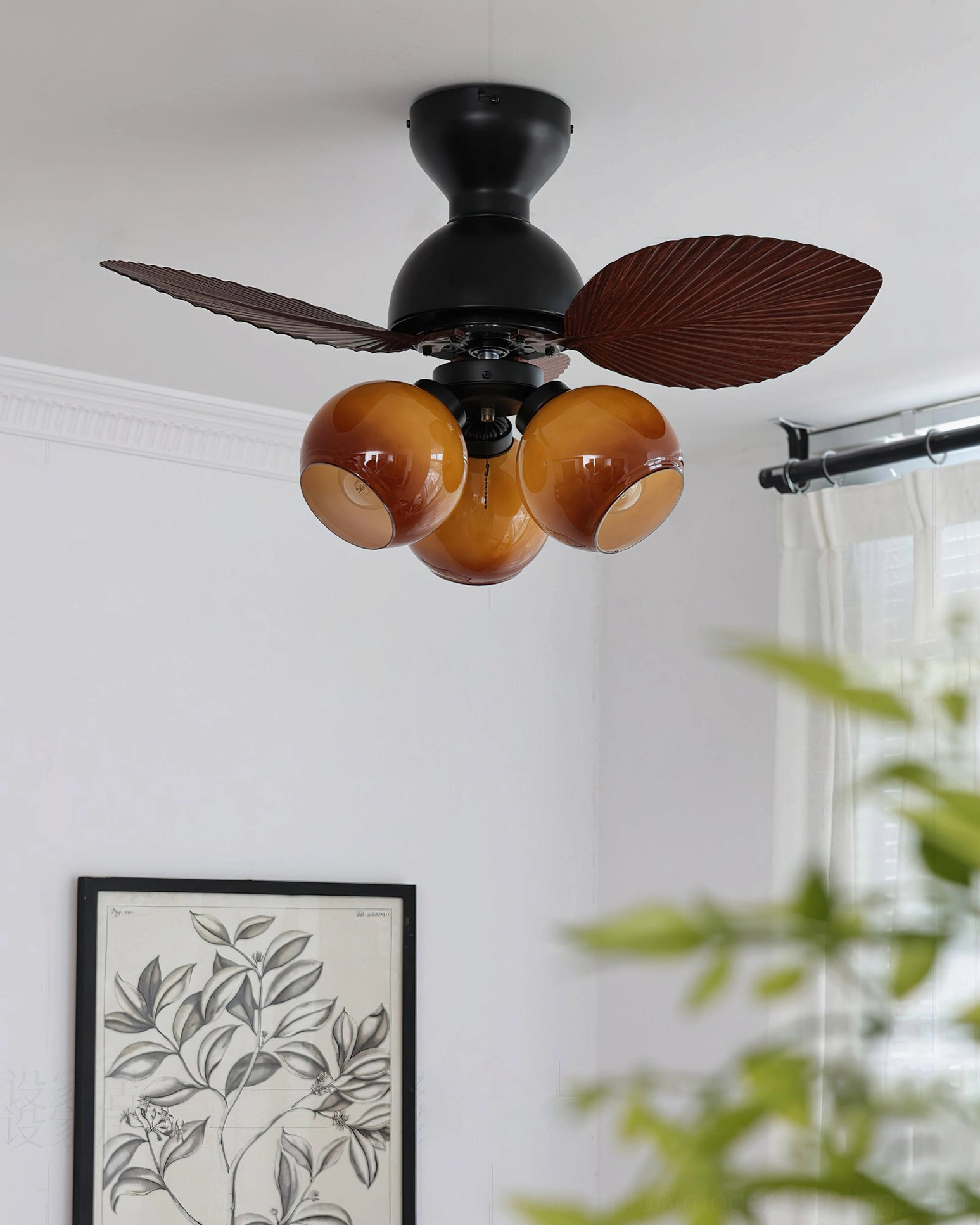 Belize tropical ceiling fan light close-up side view with amber glass lamp covers against white wall