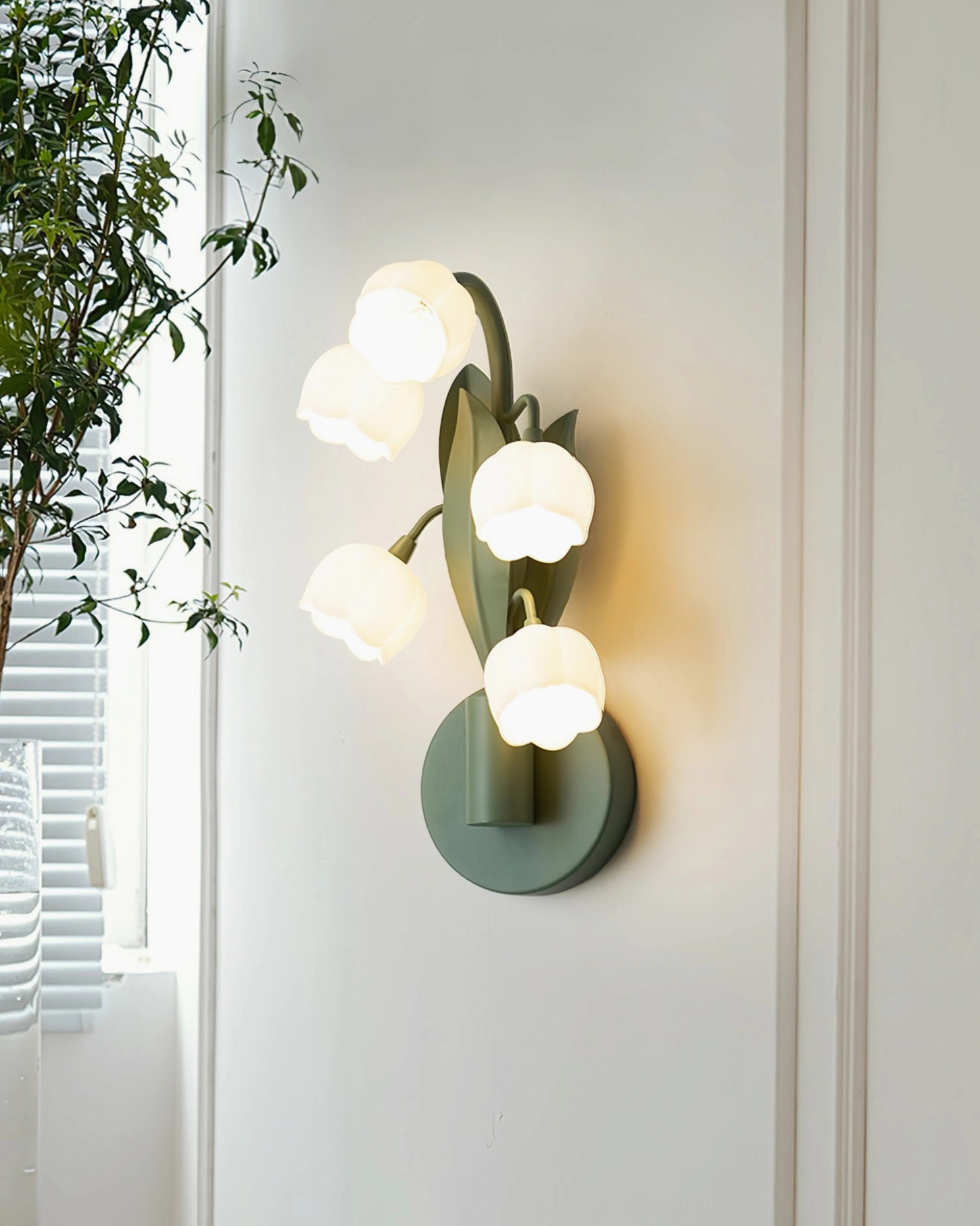 Bell Orchid botanical wall lamp mounted in hallway with green plants creating natural biophilic home decor aesthetic