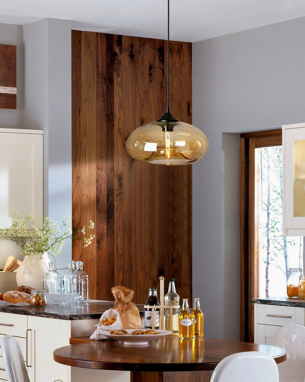 Bella hand-blown glass pendant with amber-yellow tones in modern kitchen dining area, warm contemporary lighting