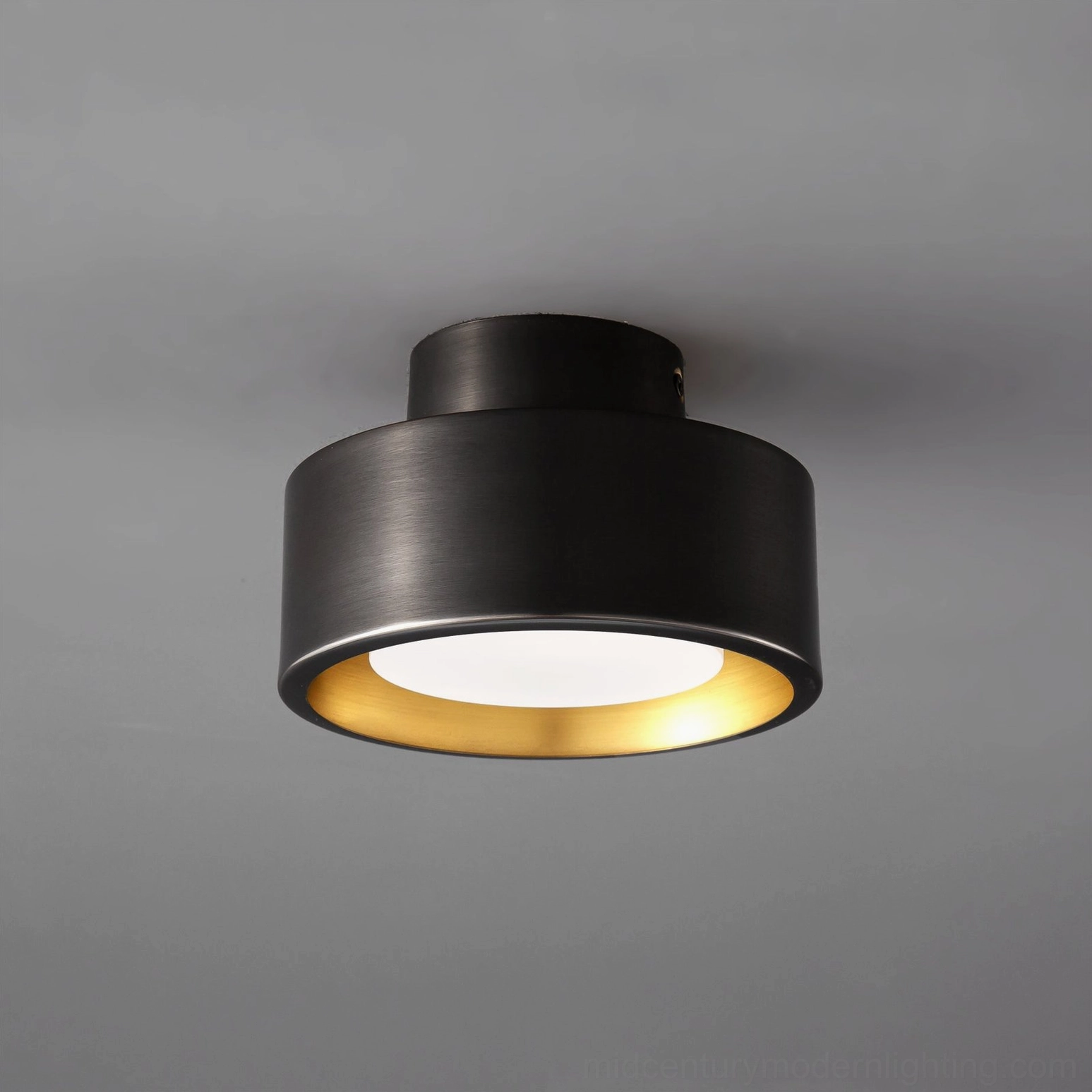 Overhead close-up of Bella black and gold flush mount ceiling lamp showing matte black exterior with brushed gold interior trim