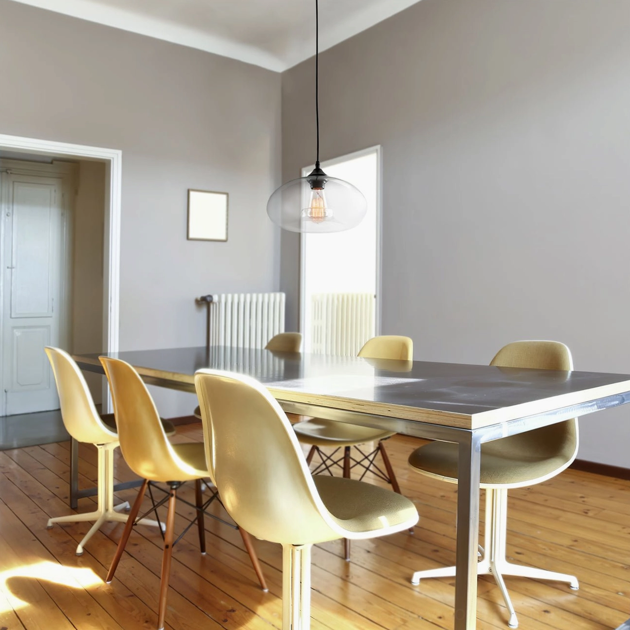 Bella clear glass pendant light showing visible Edison bulb glow through translucent shade, mid-century modern style