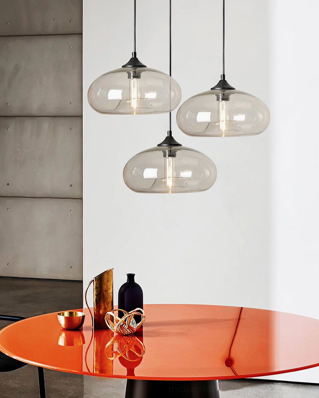 Three Bella glass pendant lamps clustered above orange round table, modern dining room with industrial aesthetic