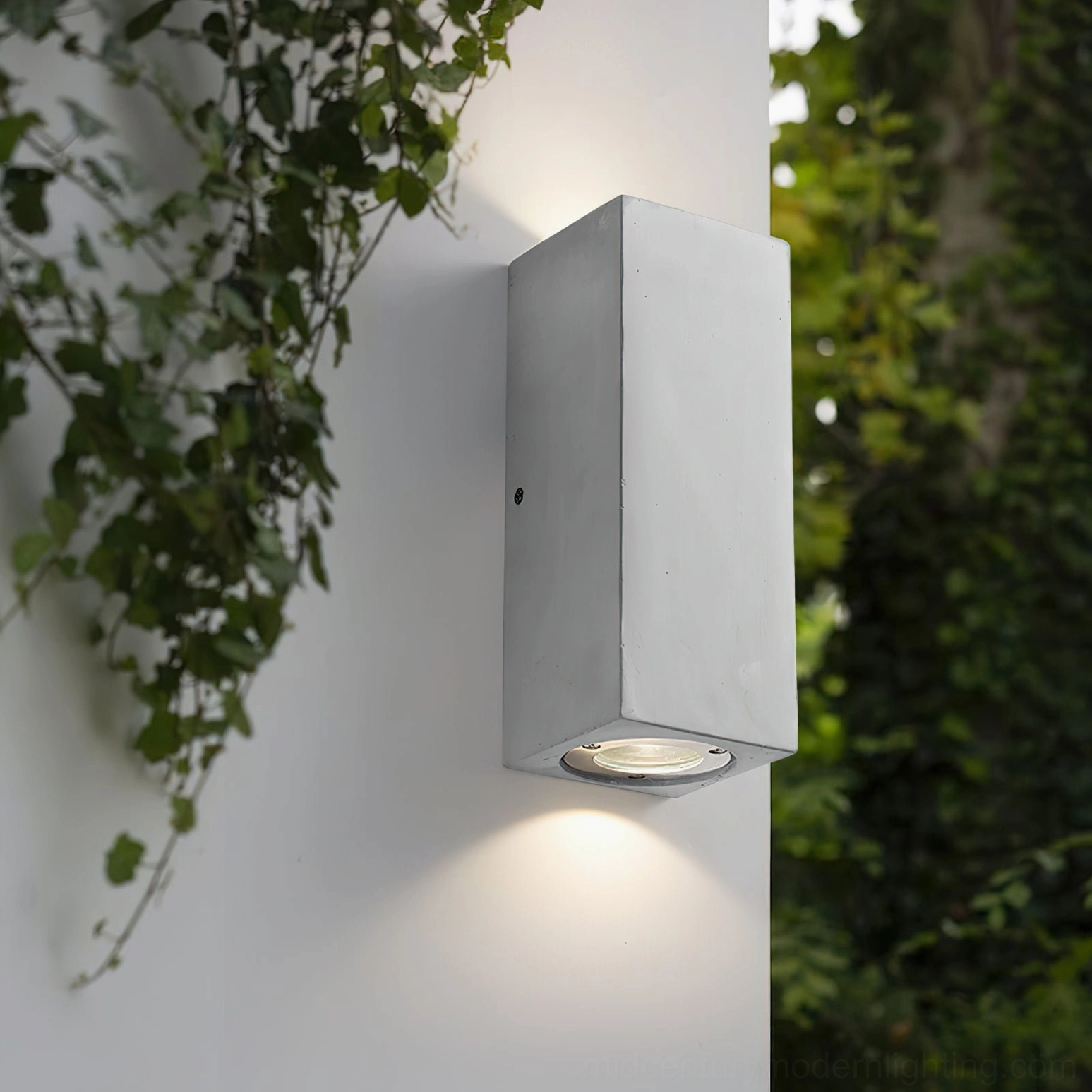Bentu rectangular wall lamp outdoor entryway with warm downlighting against green foliage backdrop