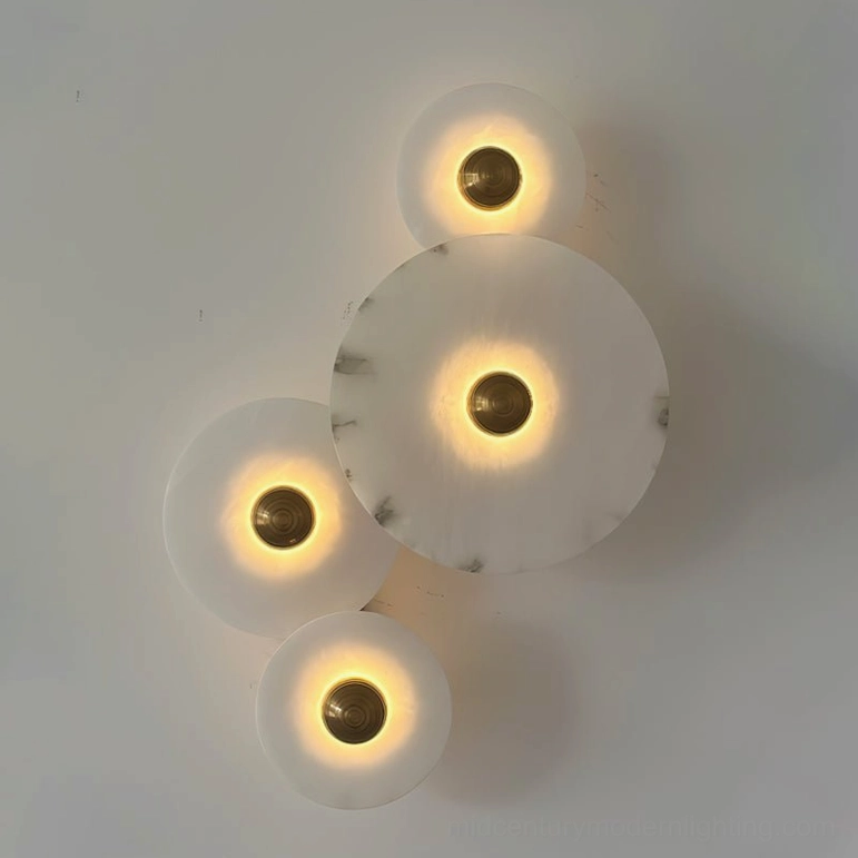 Beran alabaster wall lamp studio close-up showing four cascading disc shades, warm backlit translucent alabaster, and polished brass hardware mounting details
