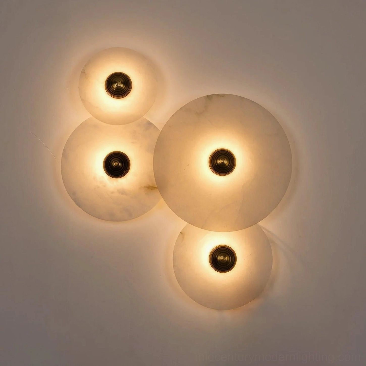 Beran alabaster wall lamp fully illuminated angled view, warm diffused light through natural veined stone creating soft glowing ambient effect, mid-century modern sconce design