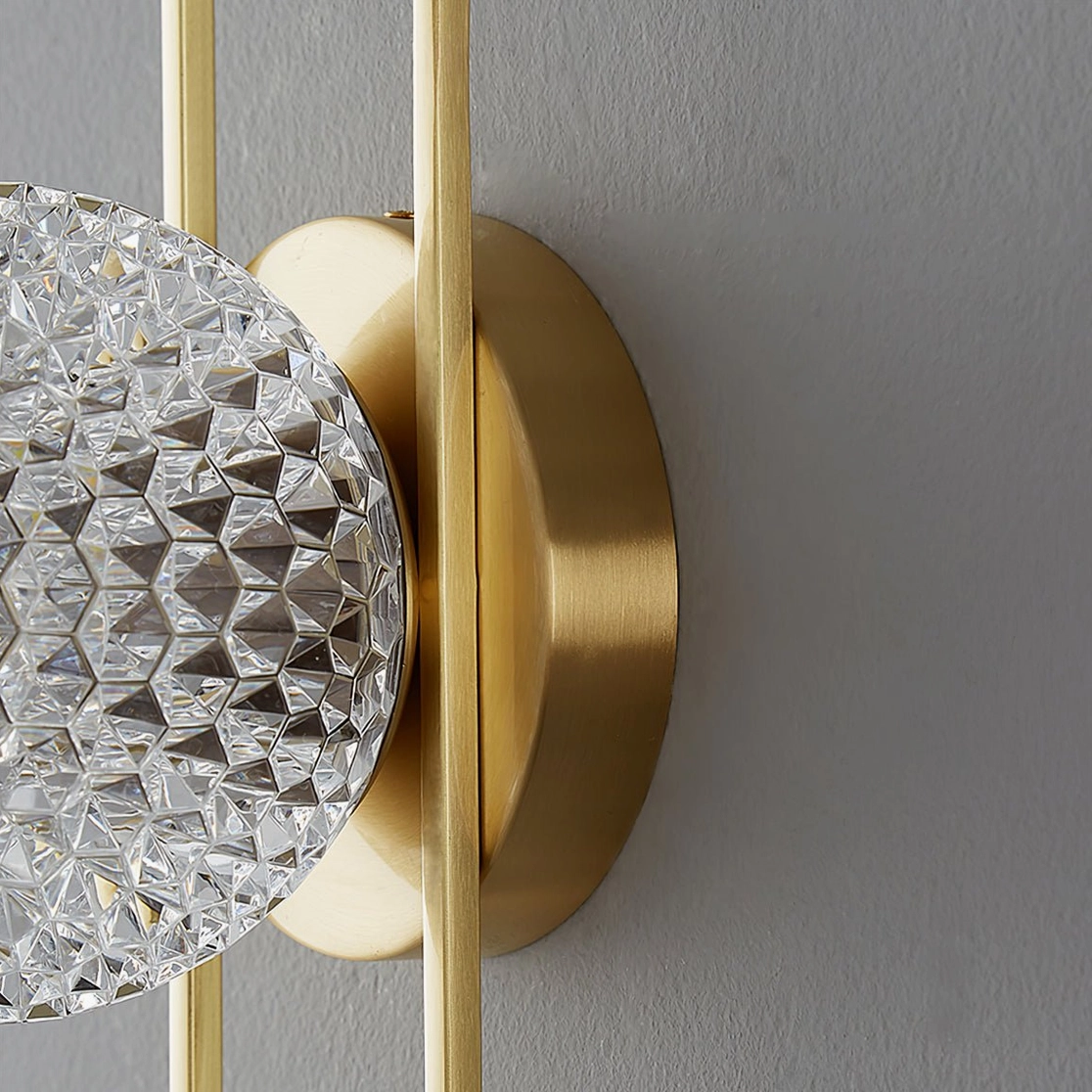 Side view of Bervalo wall sconce showing geometric cut crystal and brushed brass finish detail