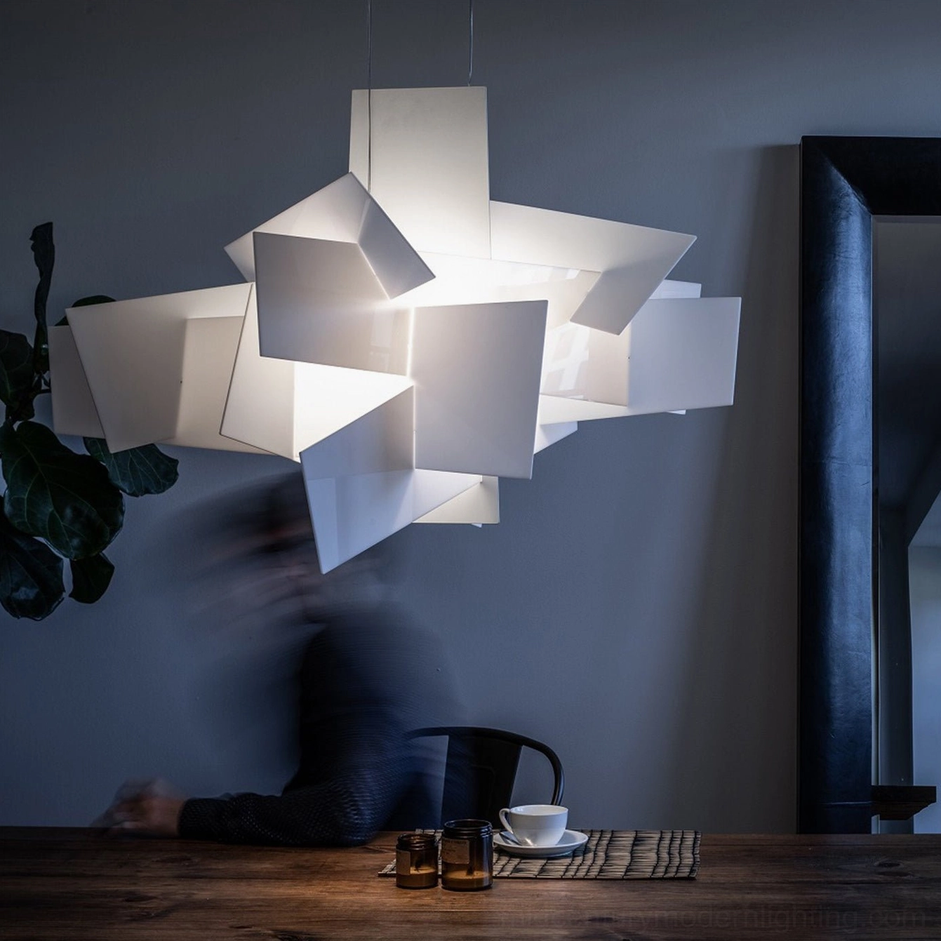 Big Bang pendant chandelier illuminated dark modern dining room ambient warm glow ceiling fixture