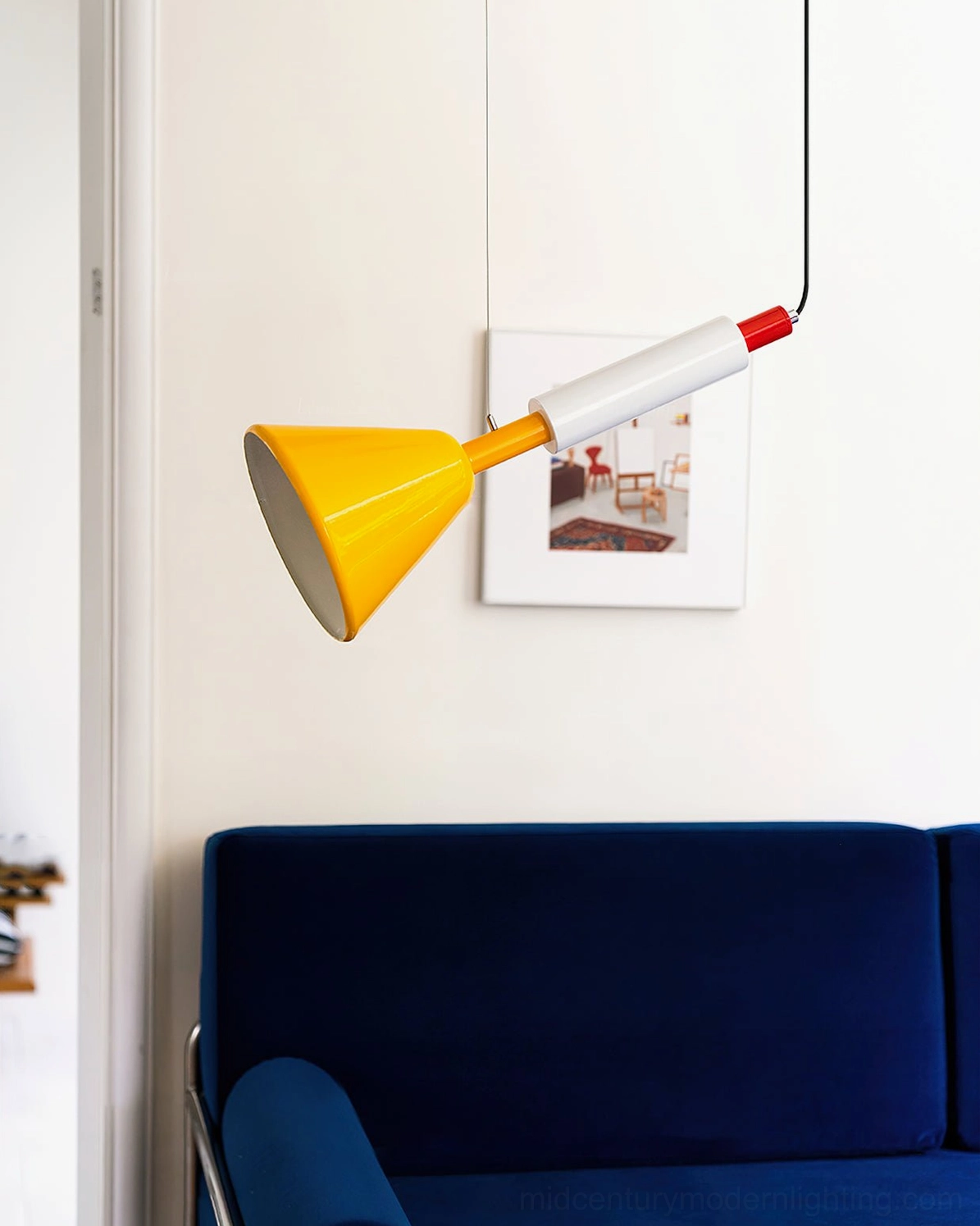 Billy cone pendant light hanging in living room with navy velvet sofa - mid-century modern interior