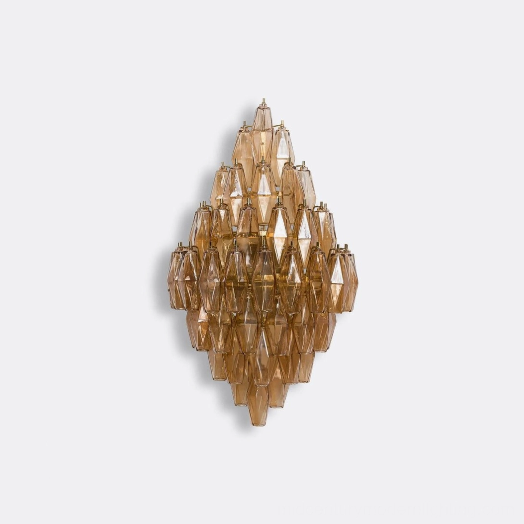 Polyhedral glass wall sconce showing layered glass construction and metal support frame