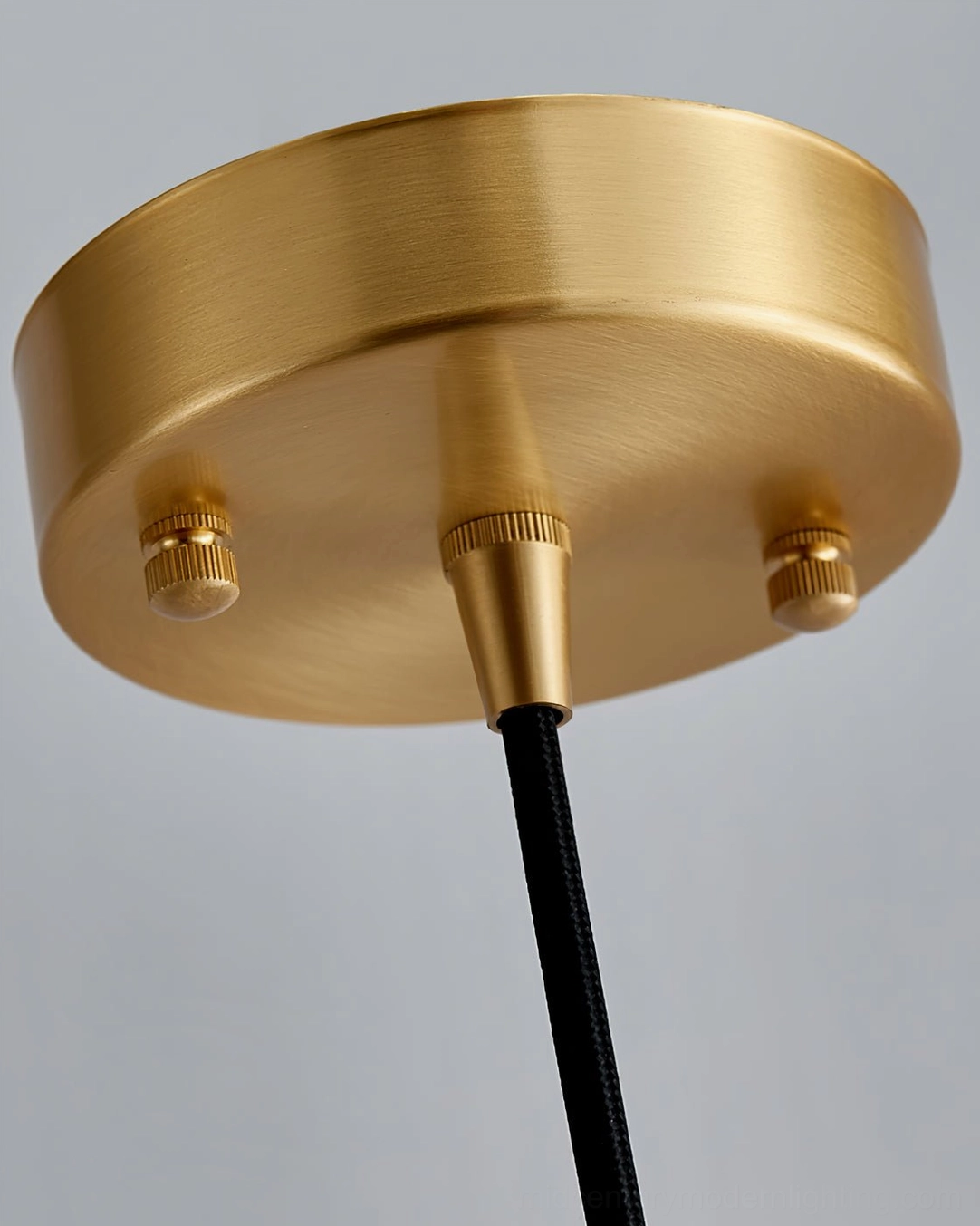 Black marble pendant light with gold brass fixture mounted in modern interior space