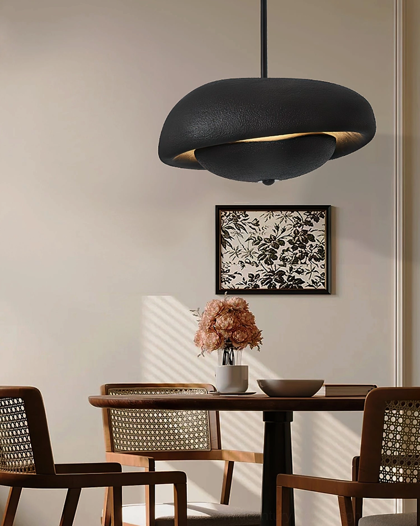 Modern minimalist black pendant lamp hanging above formal dining table with soft diffused light
