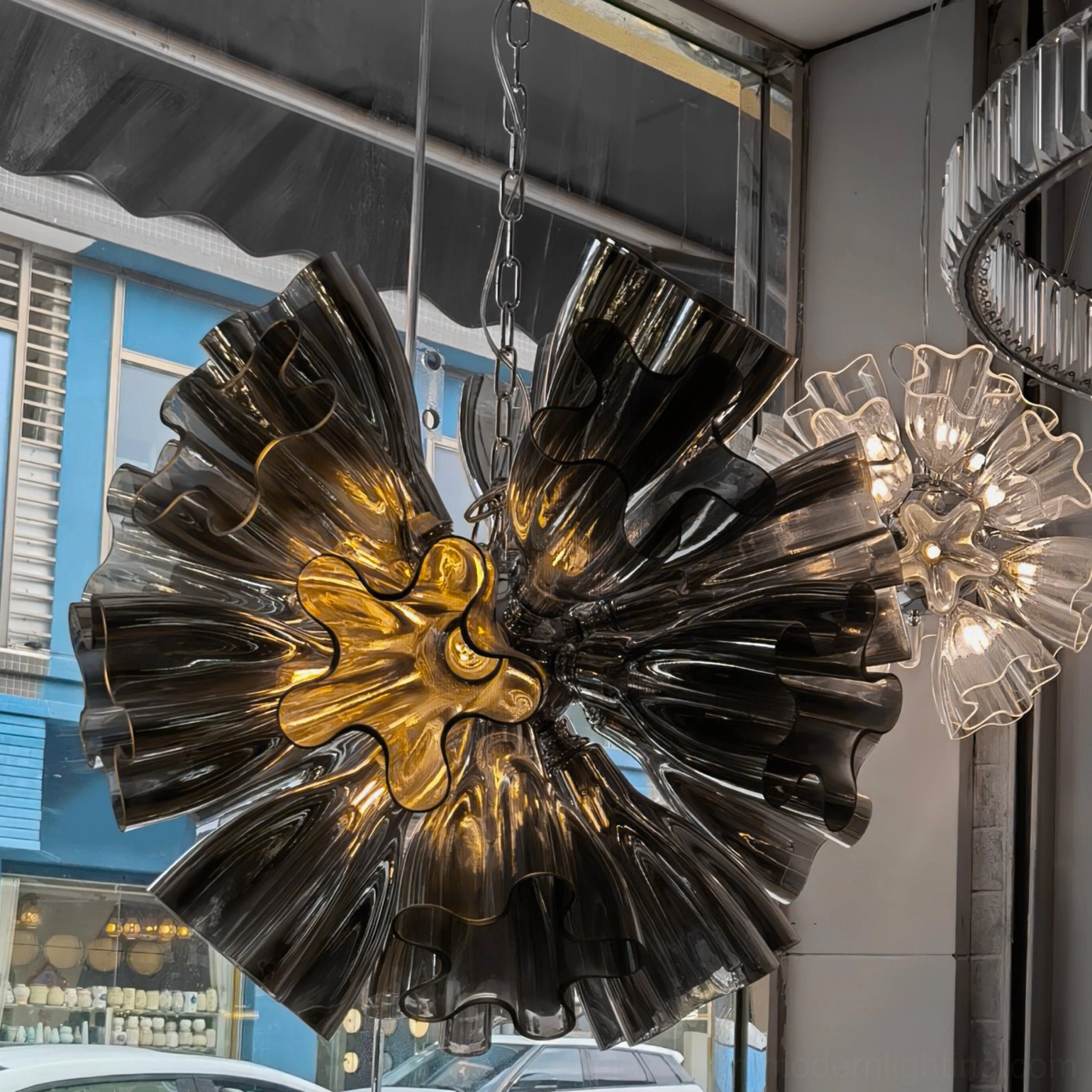 Smoke Gray ruffled glass chandelier displayed with clear glass versions in retail window showcase