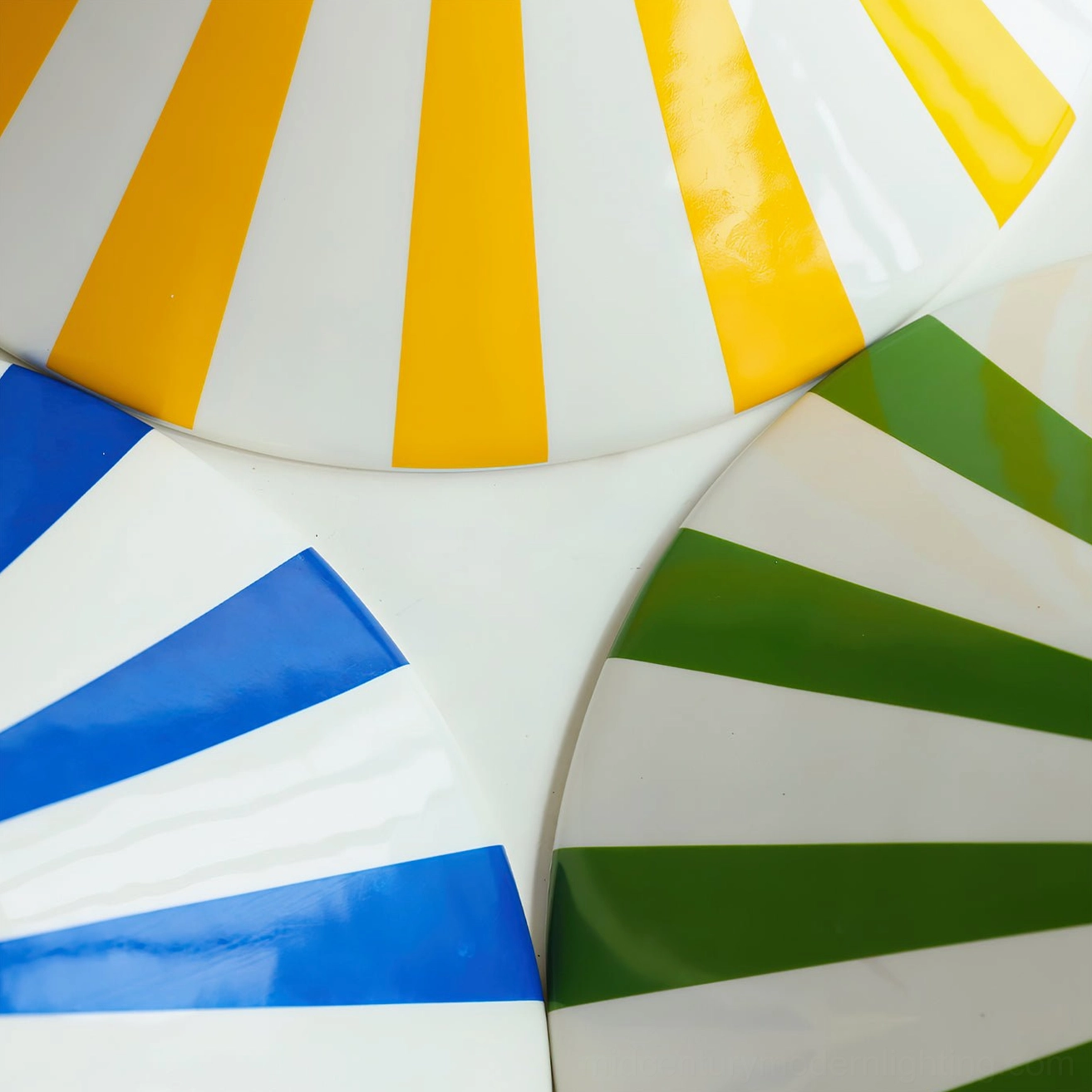 Close-up overhead view of Bobine striped glass shades showing yellow-white, blue-white, and green-white stripe patterns