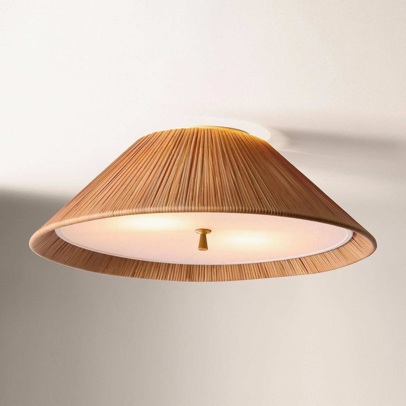 Bodie rattan flush mount ceiling light glowing with warm interior lighting