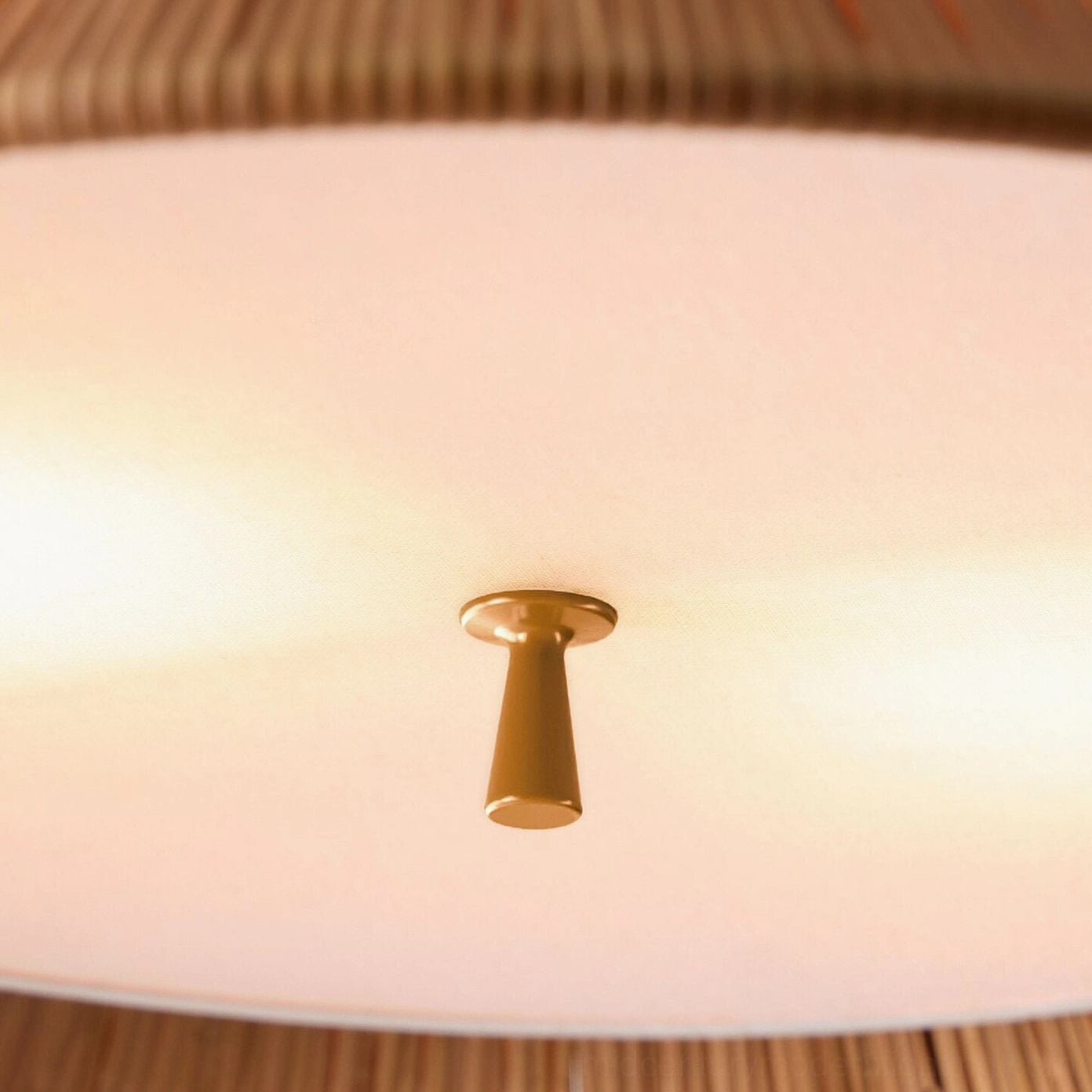 Bodie rattan ceiling fixture extreme close-up of brass metal finial and white inner diffuser detail