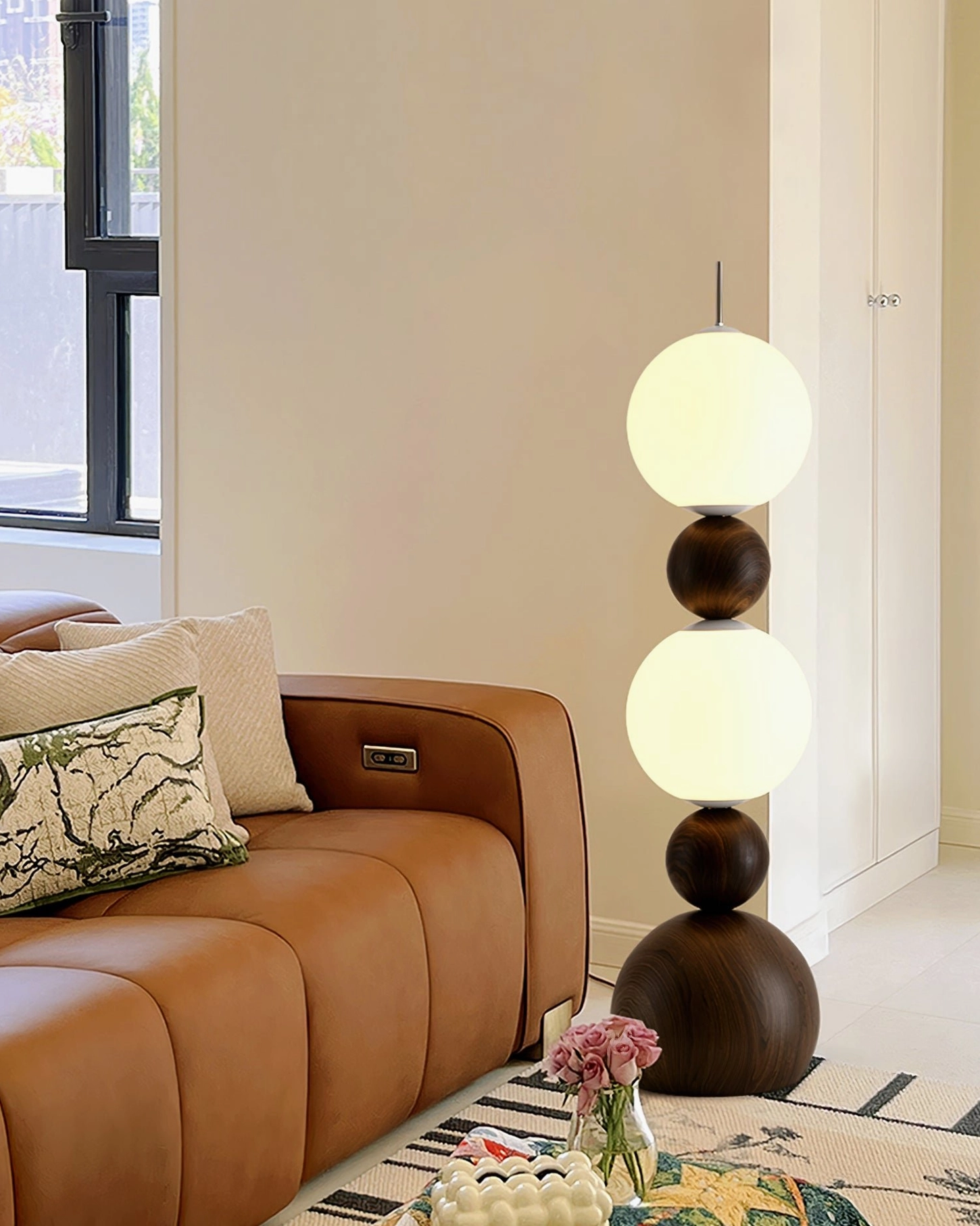 Illuminated Bola floor lamp casting warm light in mid-century modern living room with leather sofa