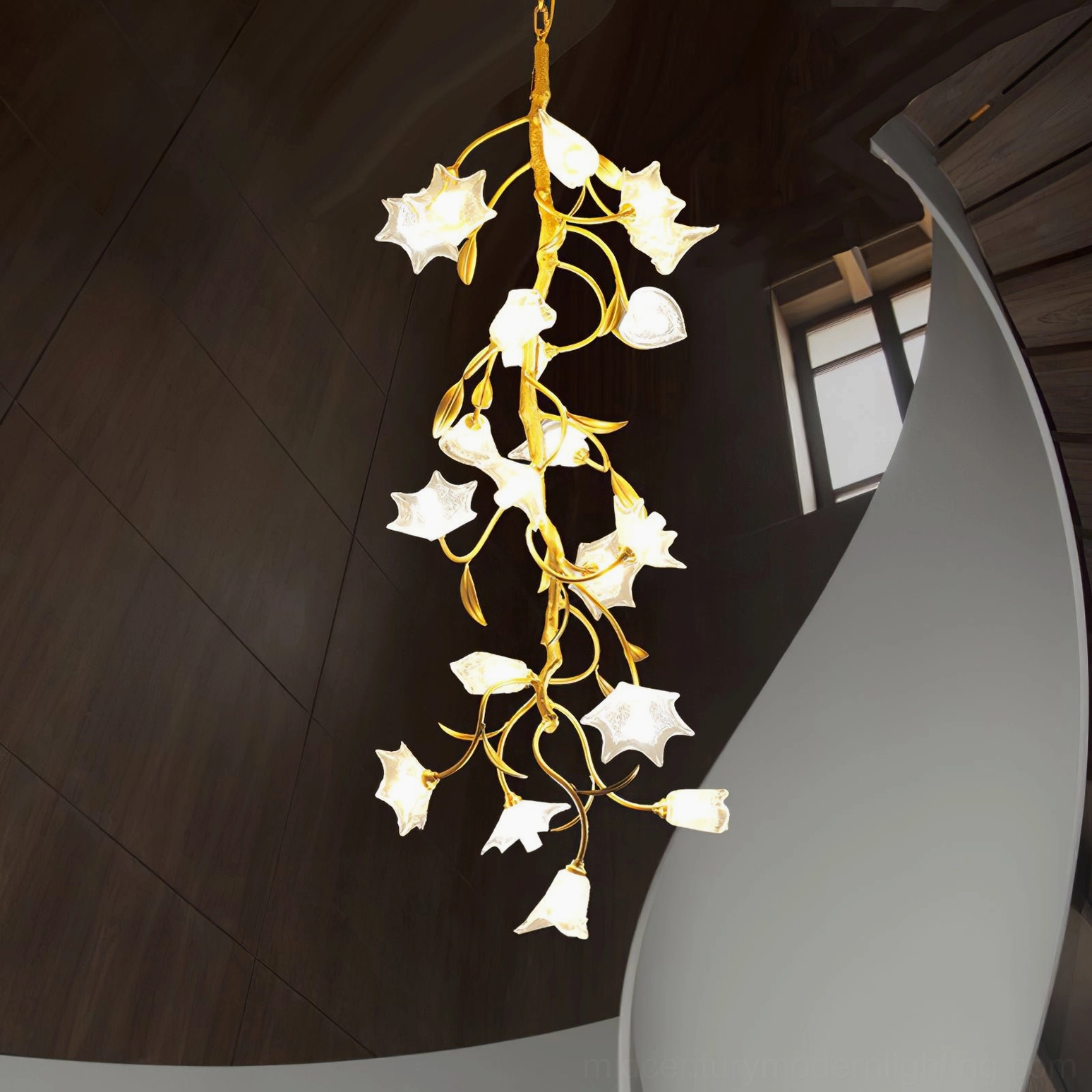 Floral glass chandelier installed in luxury spiral staircase interior with dark wood wall and gold frame details
