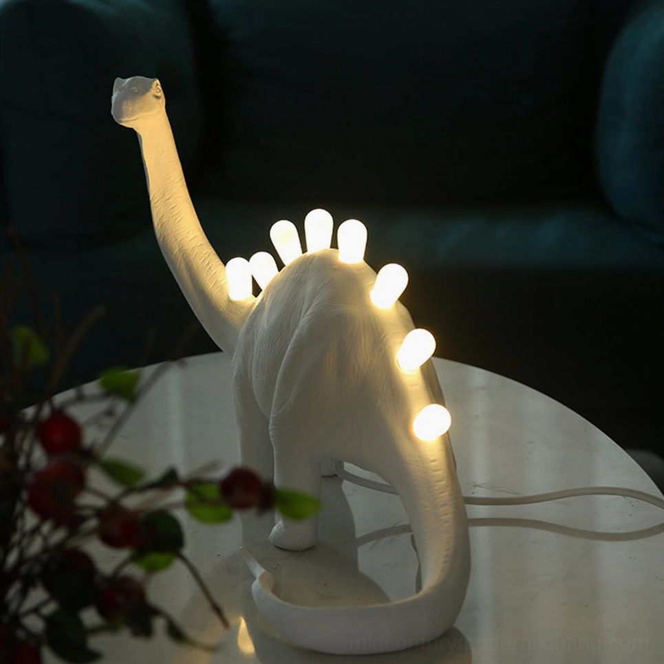 Brachiosaurus dinosaur table lamp with glowing LED spines on glass side table, living room setting