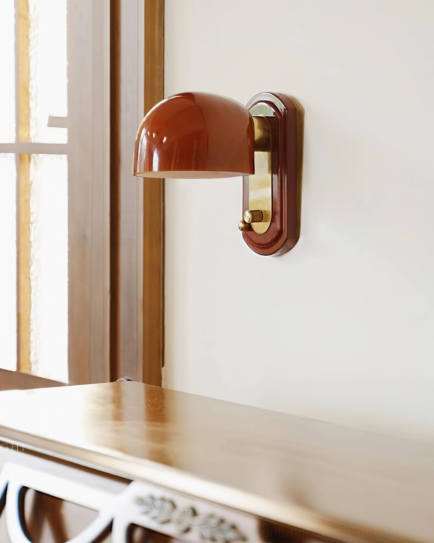 Three-quarter view of Bradley minimalist wall lamp with matte dark red shade and solid wood mounting plate