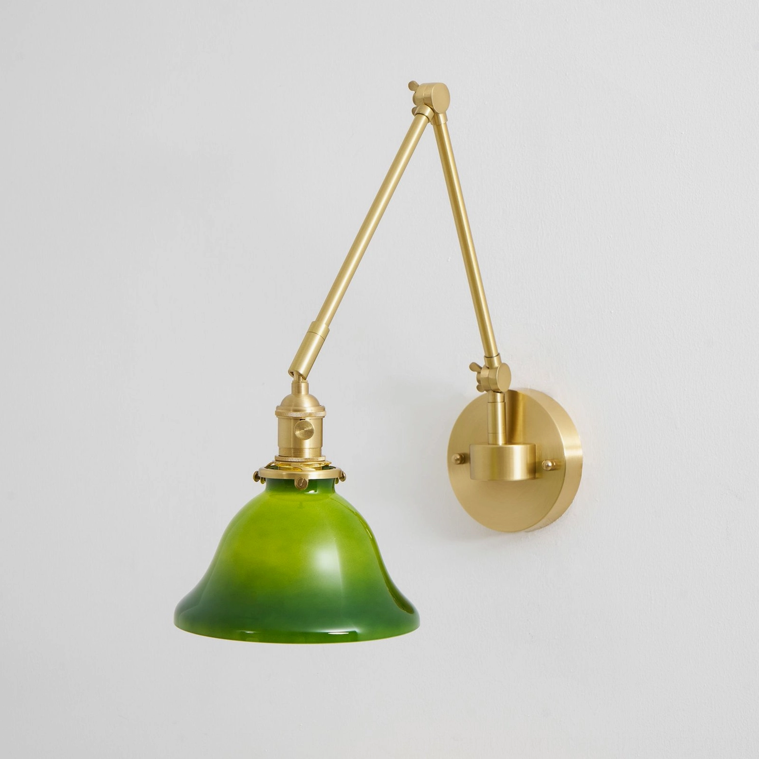 Brady brass swing arm wall lamp showing patina development and aging character