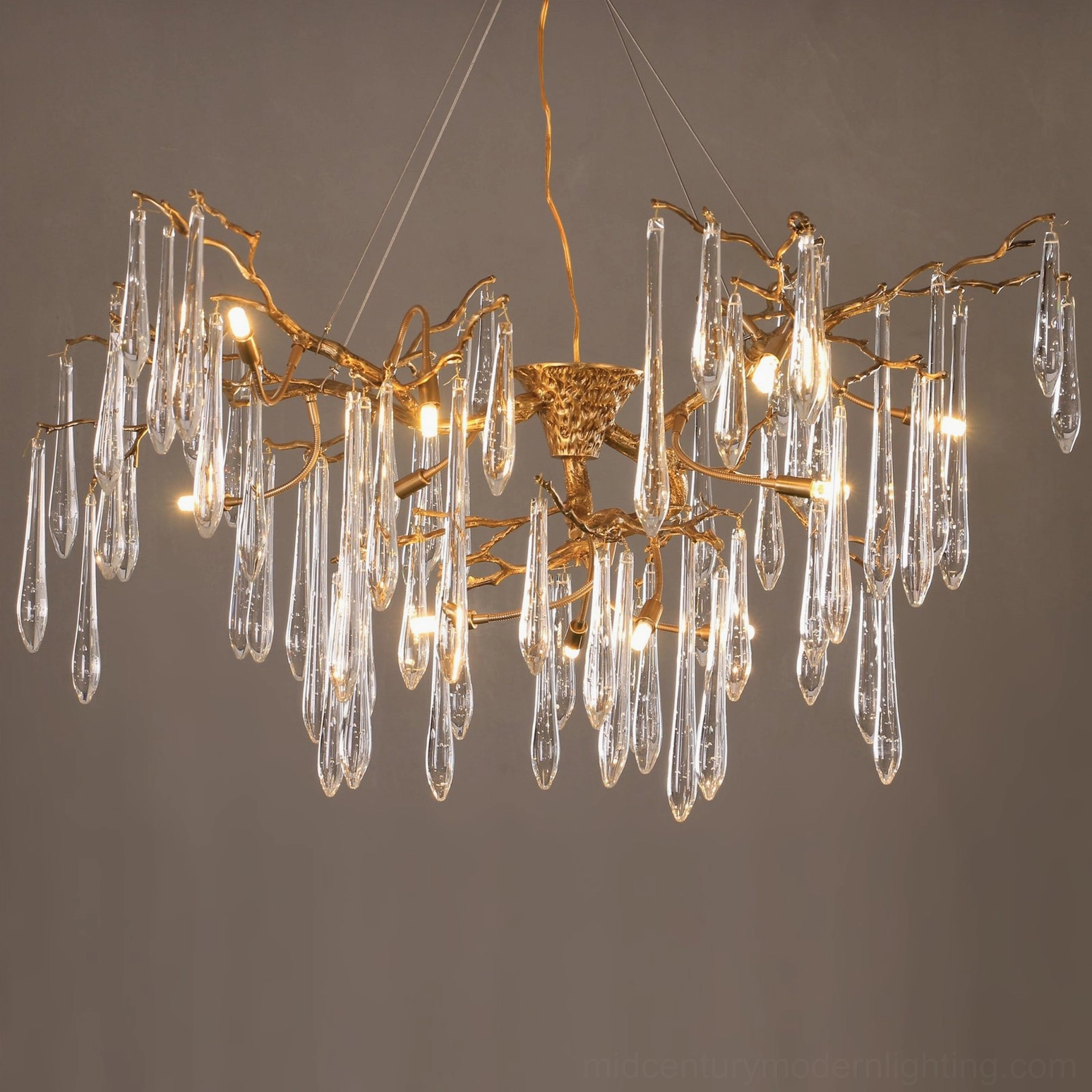 Close-up detail of Branch Raindrop Chandelier showing warm Edison bulbs and delicate crystal rain drop pendants with antique brass framework