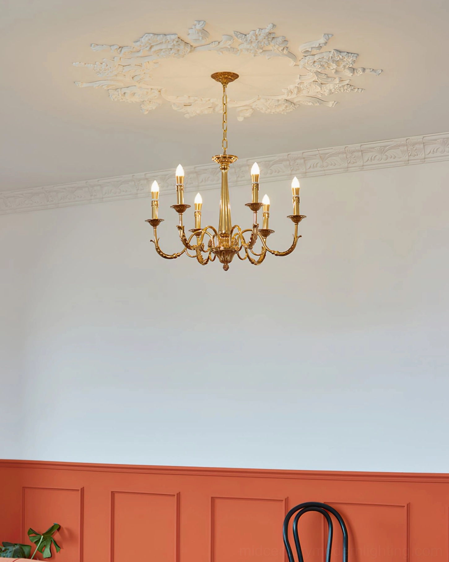 Polished brass candle chandelier showcasing ornate vintage European design and architectural details
