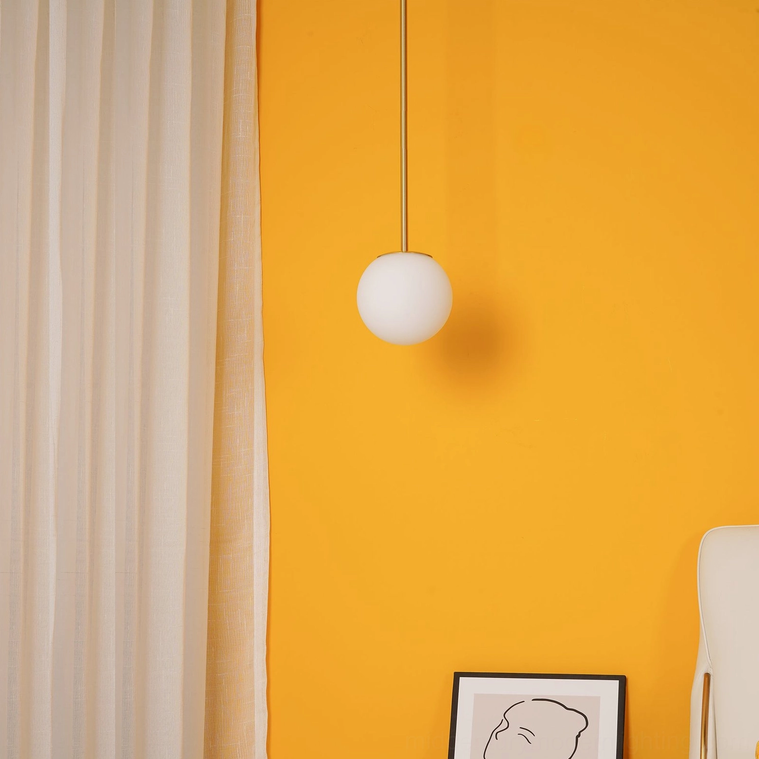 Modern brass pendant light in bedroom with warm orange accent wall creating ambient illumination