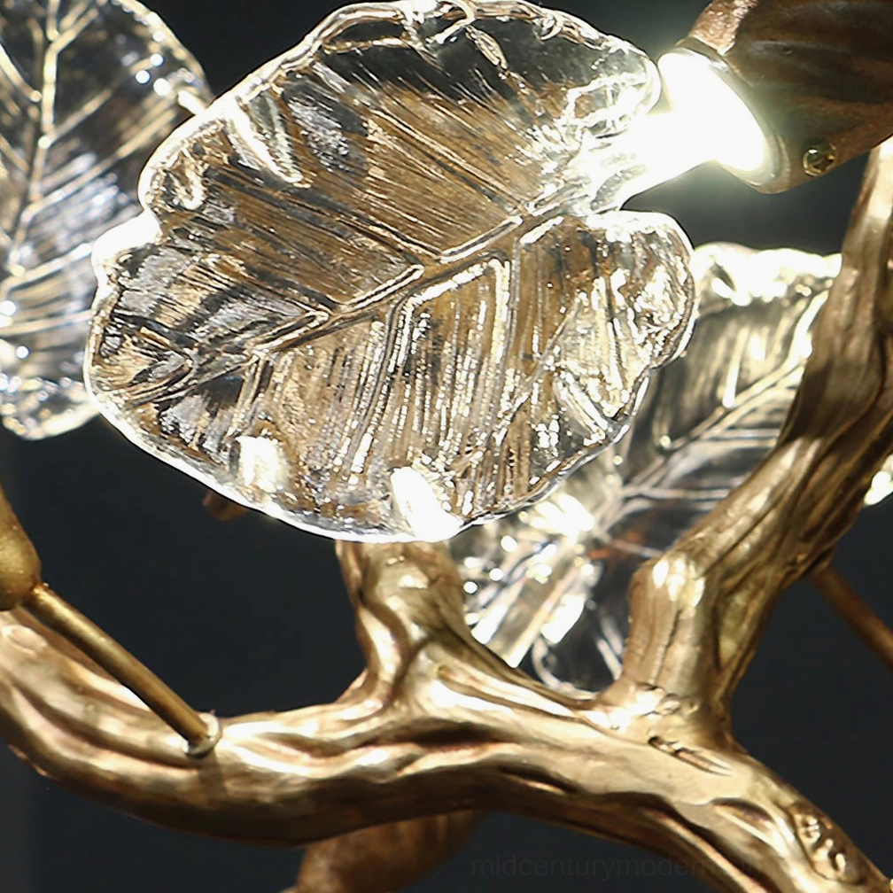 Glowing brass leaf chandelier glass detail - warm light through textured glass leaf with botanical vein texture