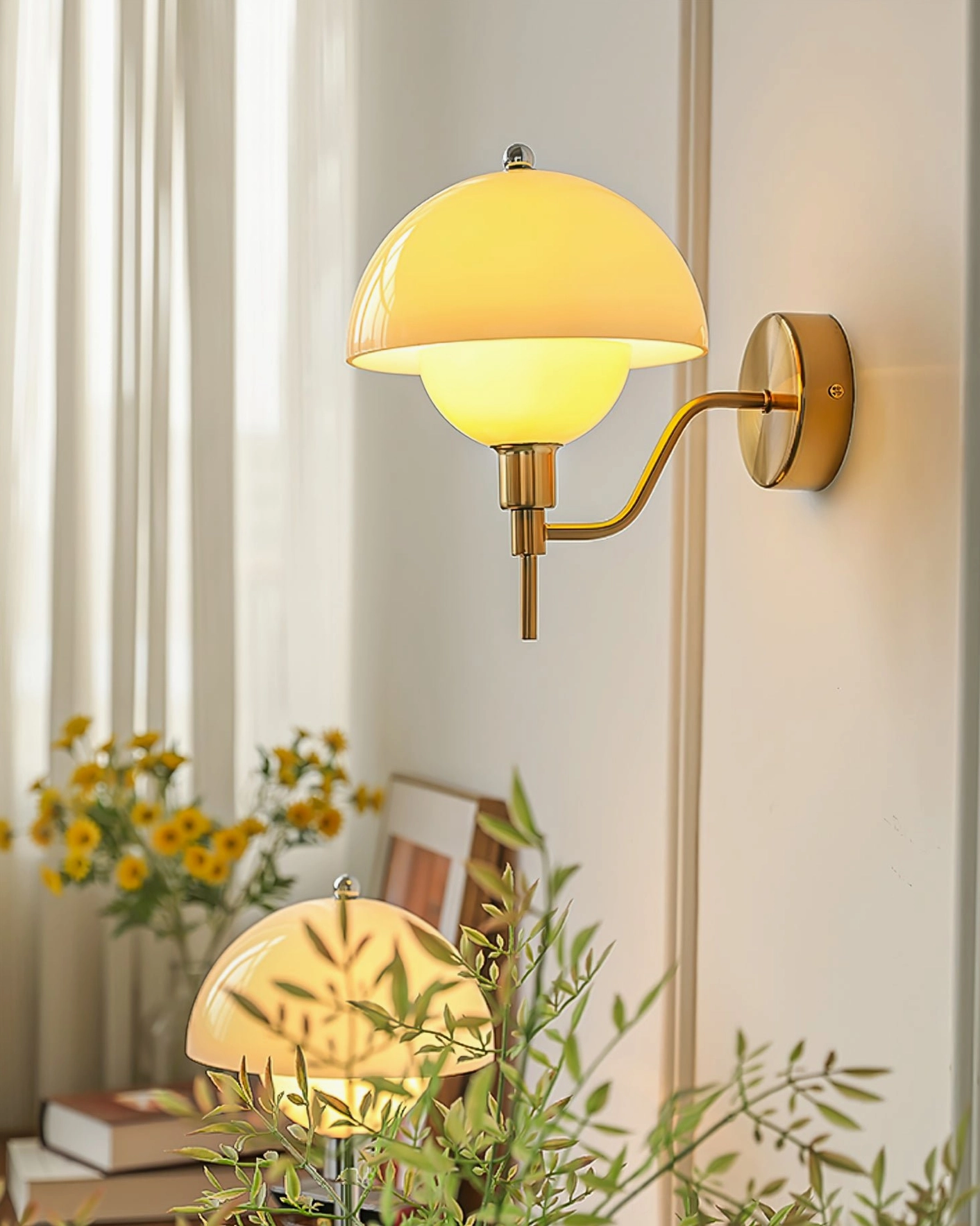 Brass mid-century orb wall lamp with yellow glass shade in vintage minimalist home setting with floral accents