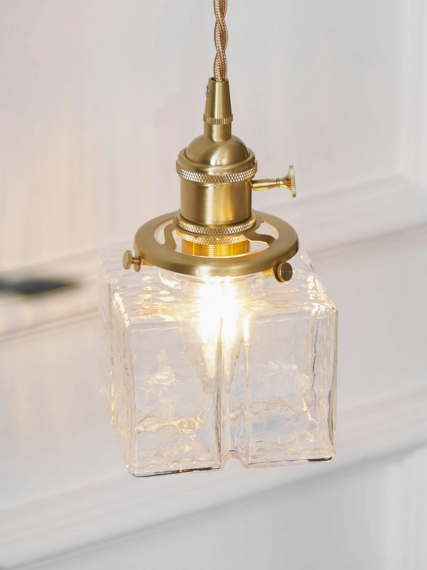 Brass pendant wall lamp with hand-textured glass mid-century modern fixture detail