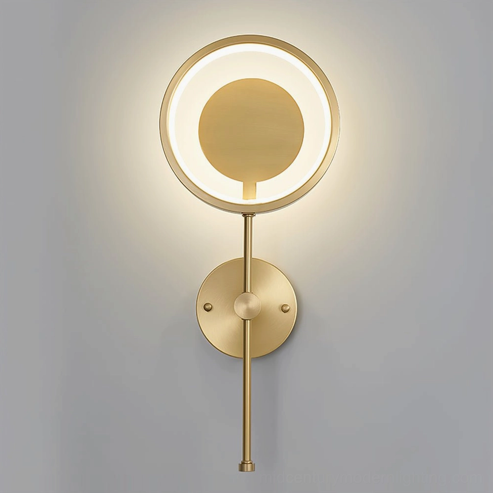 Brass finish LED ring wall lamp glowing with warm light in contemporary interior space