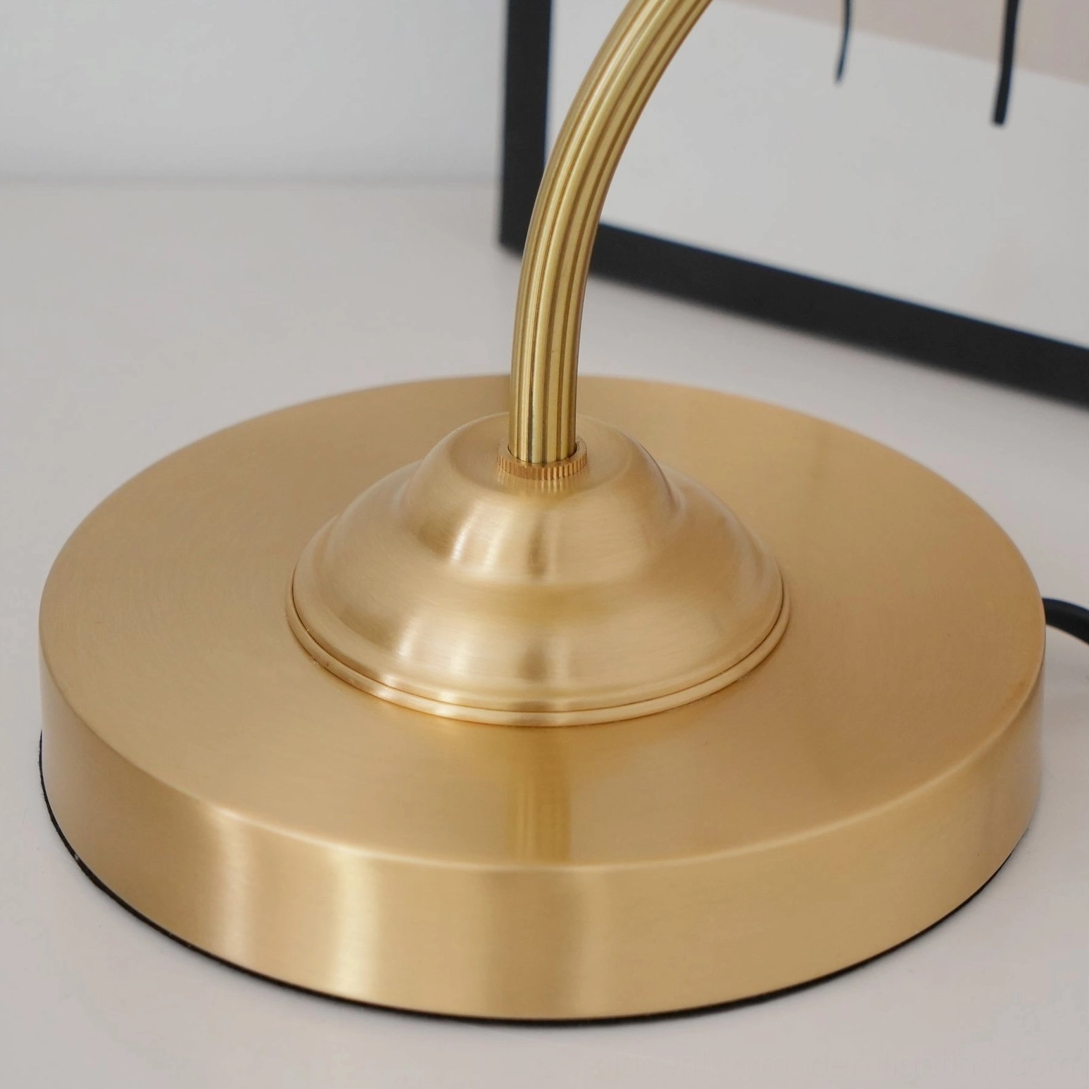 Brass umbrella table lamp in contemporary interior setting with modern furnishings