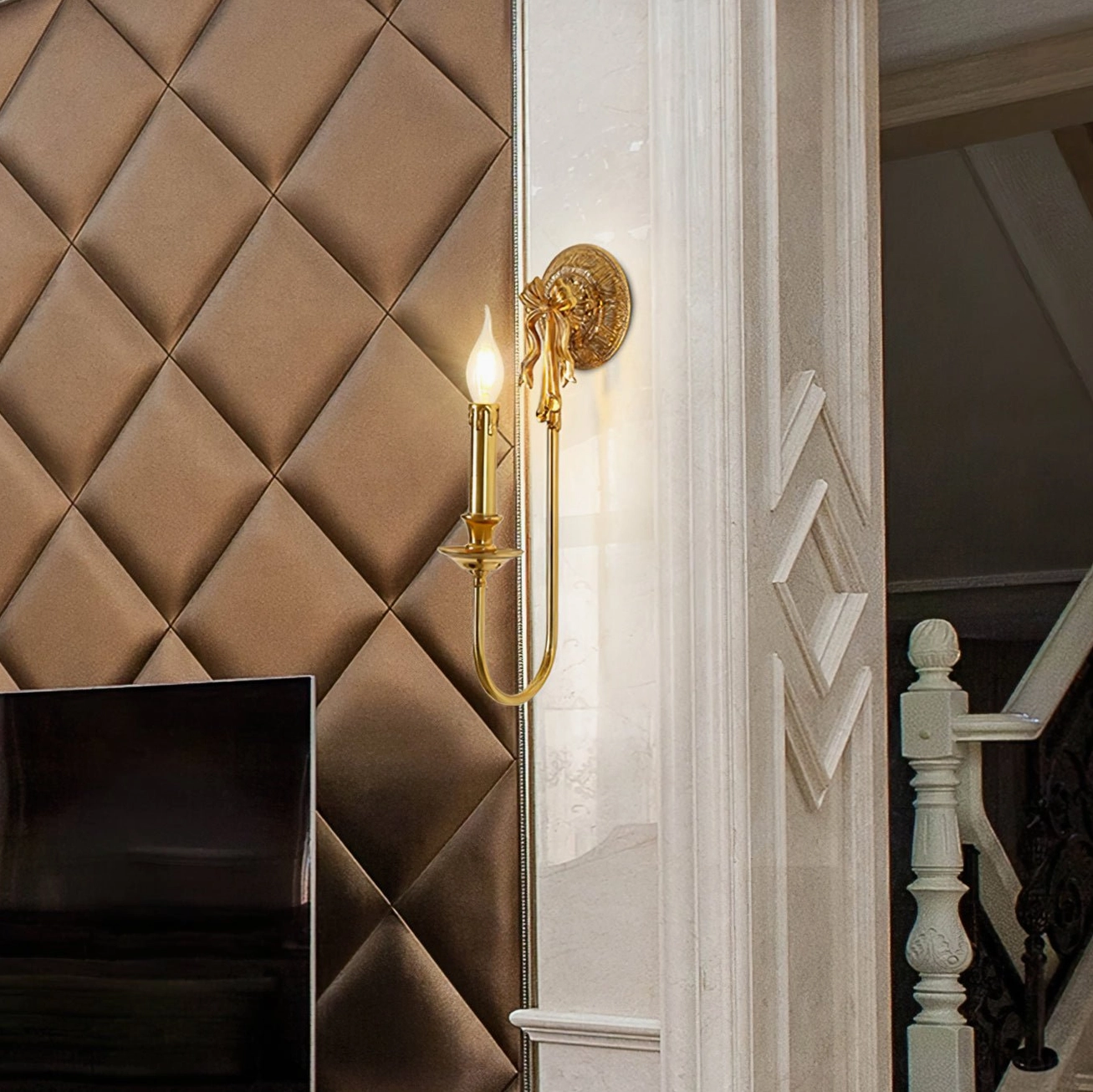 Brass wall light in hallway above staircase with quilted leather wall background