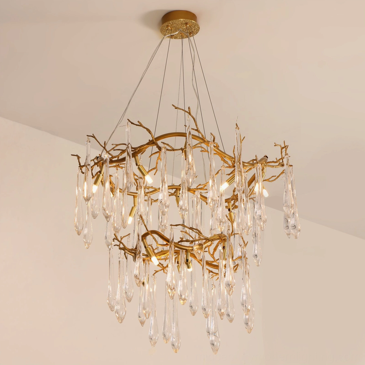 Slanted front view of brass waterfall chandelier showing organic double-tier branch shape design and cascading teardrop crystal glass pendants