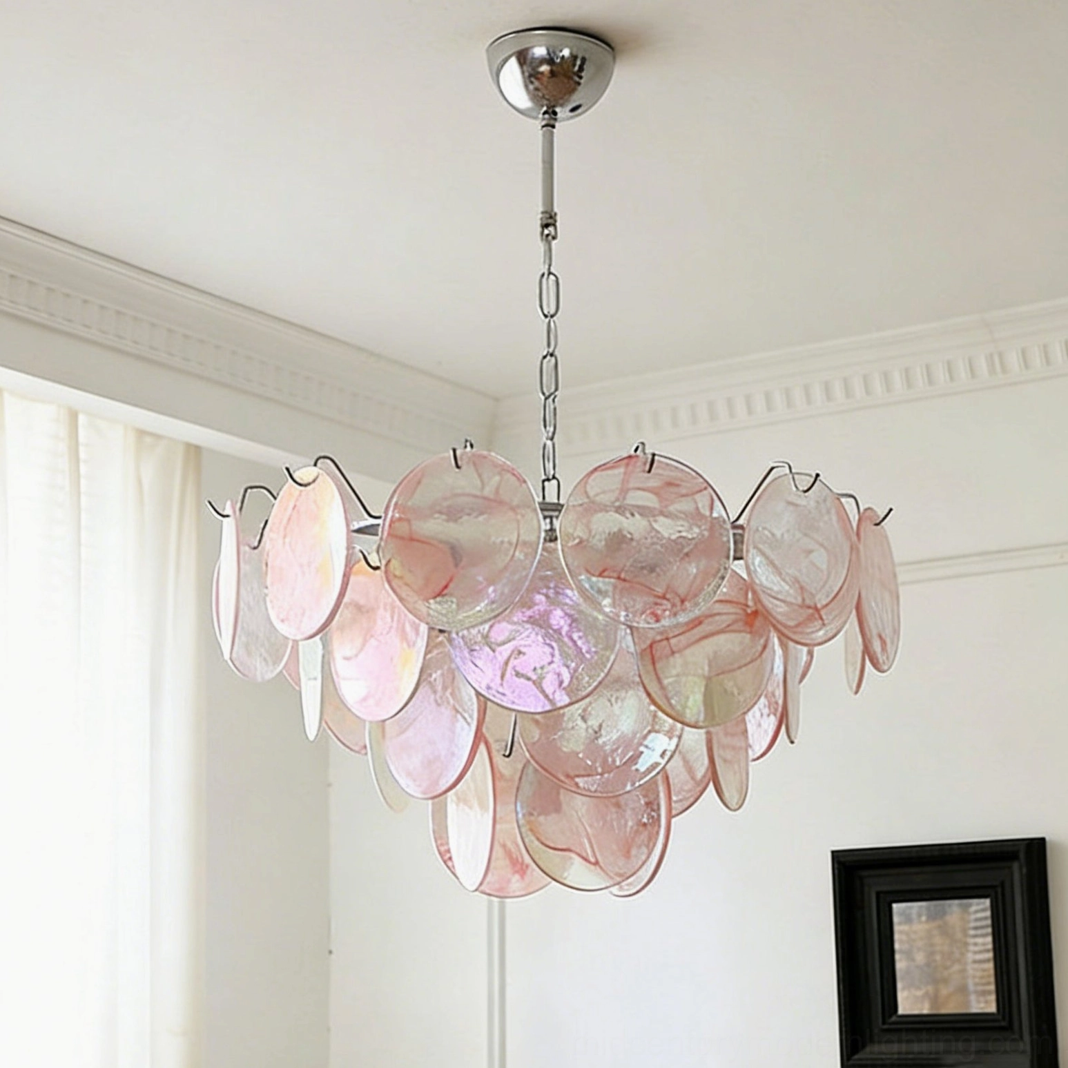 Brette pink gradient glass disk chandelier illuminated in bedroom with crown molding and layered disc structure visible