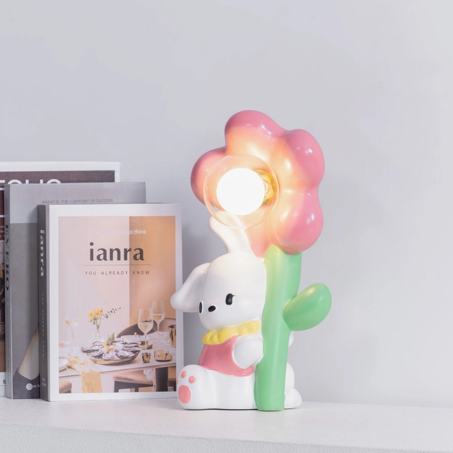 Bunny Flower Table Lamp side view on bookshelf with pink floral shade and decorative styling