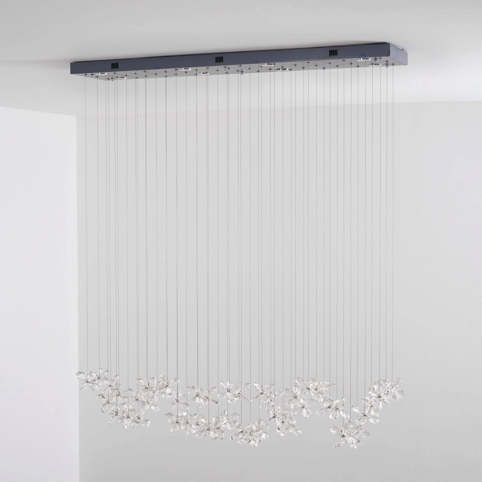Crystal butterfly pendant arrangement detail, multiple faceted crystal flowers in adjustable configuration, modern sculptural LED lighting design