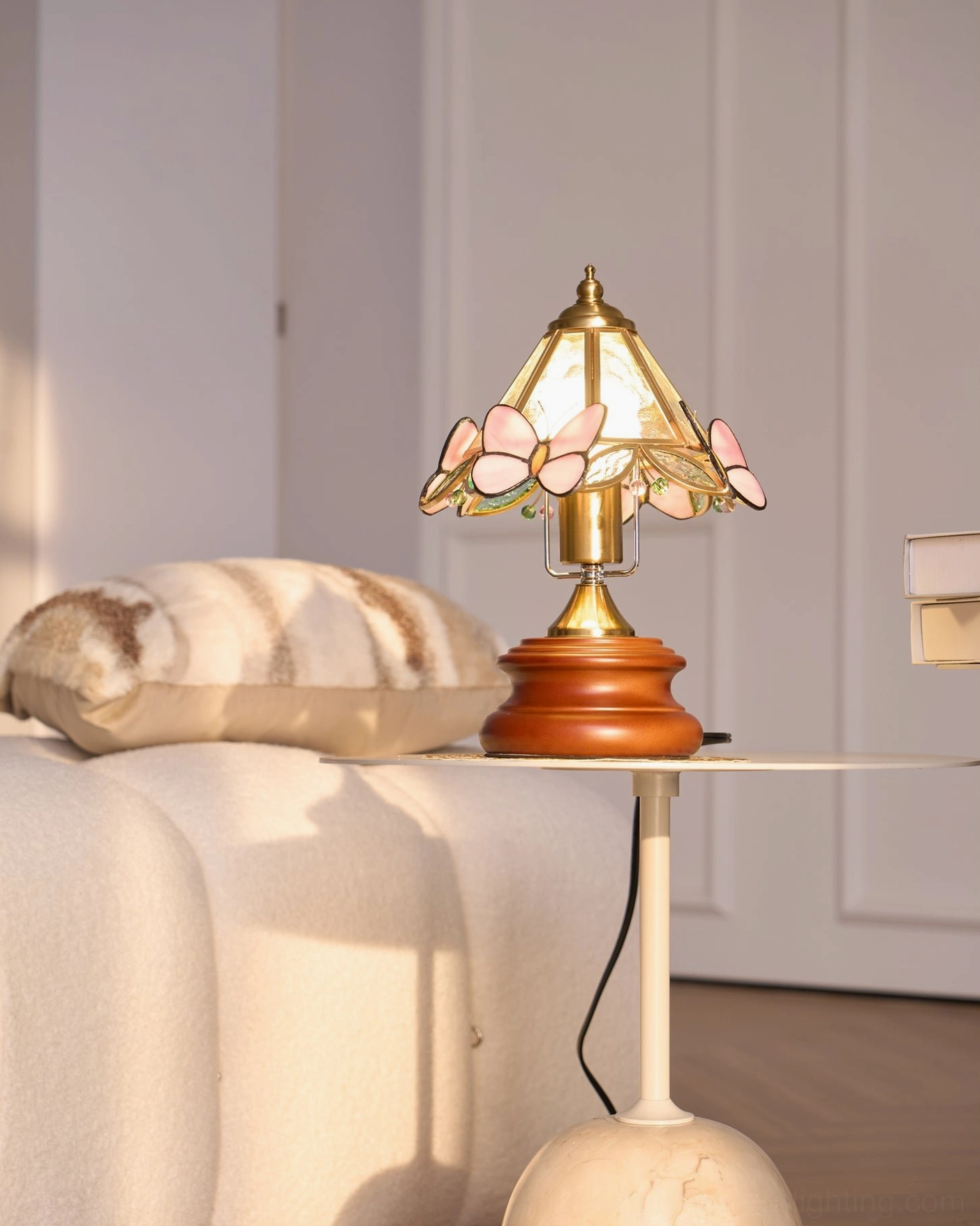 Mid-century modern butterfly table lamp positioned on bookshelf with collected vintage items and books
