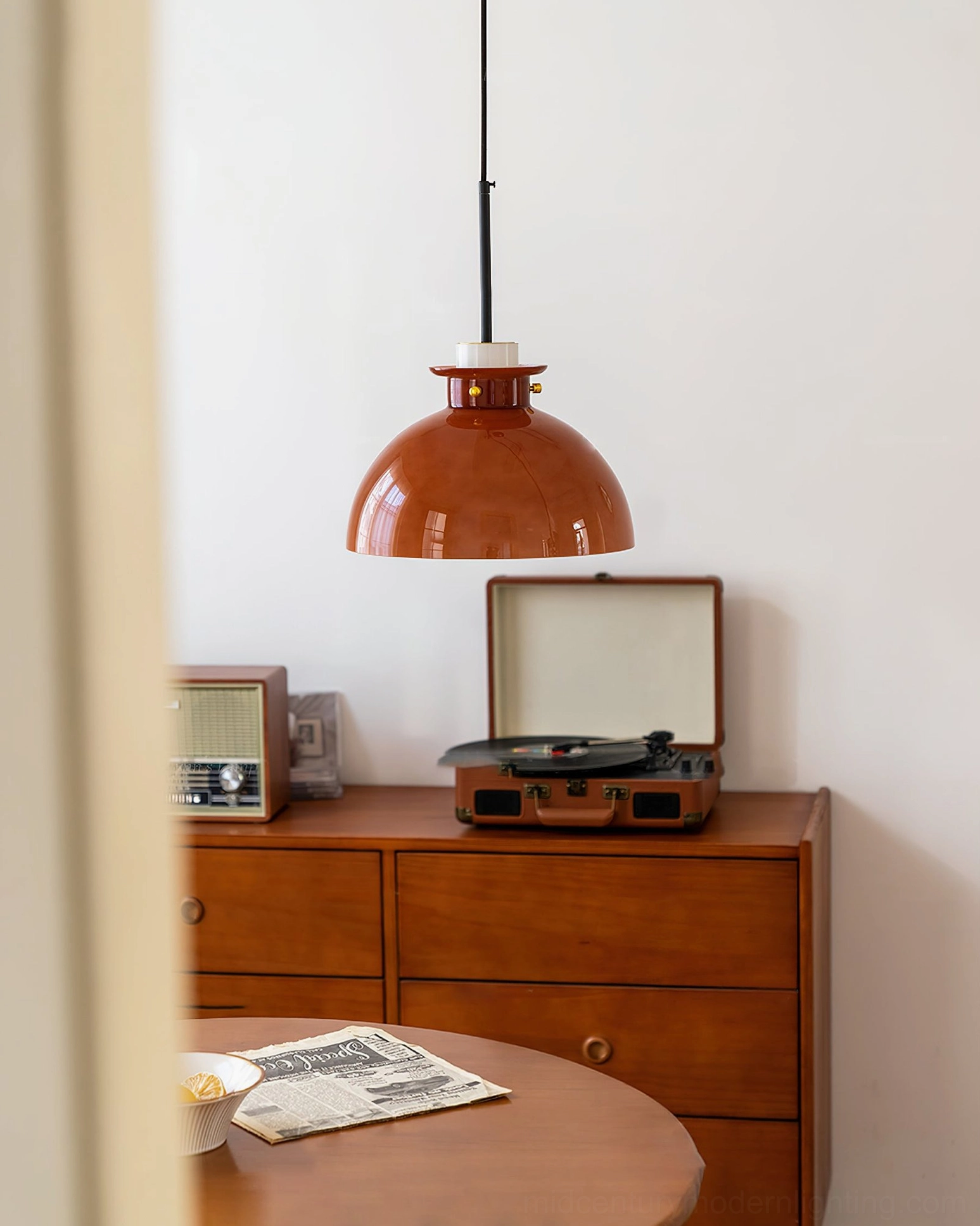 Cabras pendant light in vintage home dining space, oblique view through doorway showing glossy caramel glass and warm retro tones