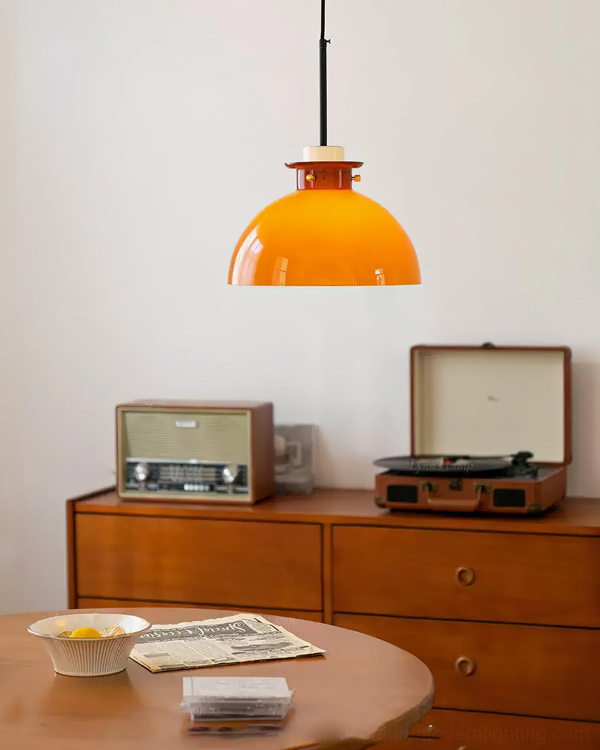 Cabras ceiling pendant with amber inner glow and caramel brown outer glass cover, overhead view above retro dining table