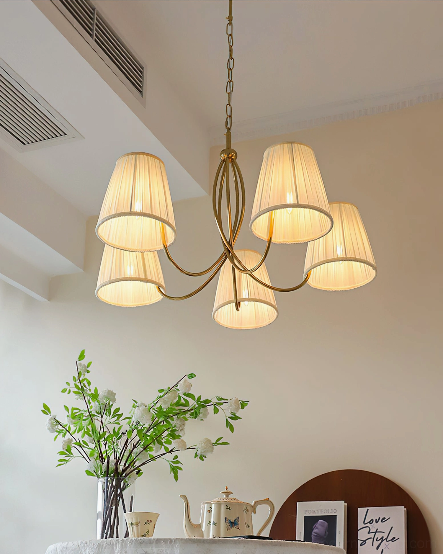 Calistoga chandelier glowing with warm yellow light, three-quarter front view in cozy home setting