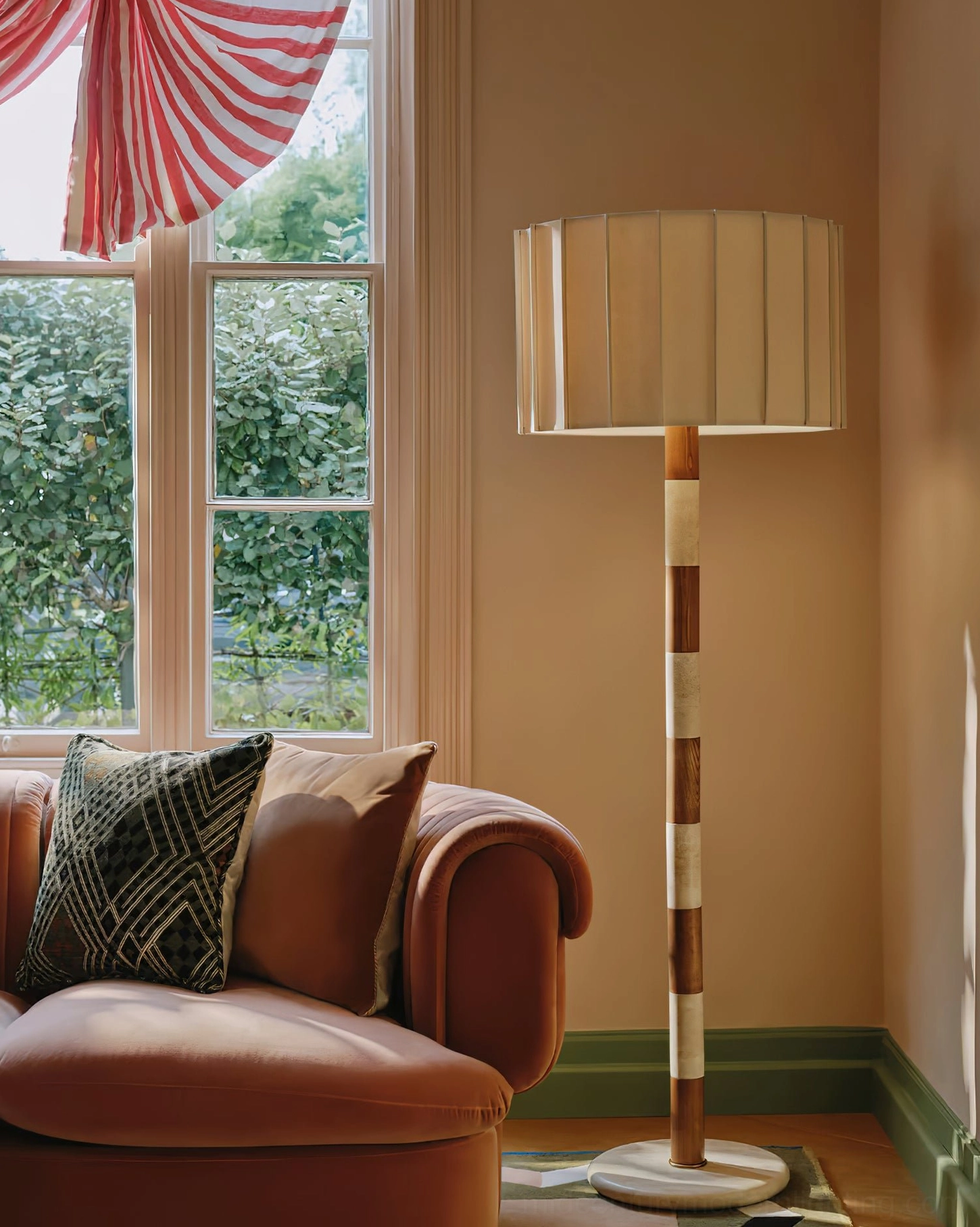 Calypso modern floor lamp beside velvet sofa in warm bohemian living room, pleated shade casting ambient light
